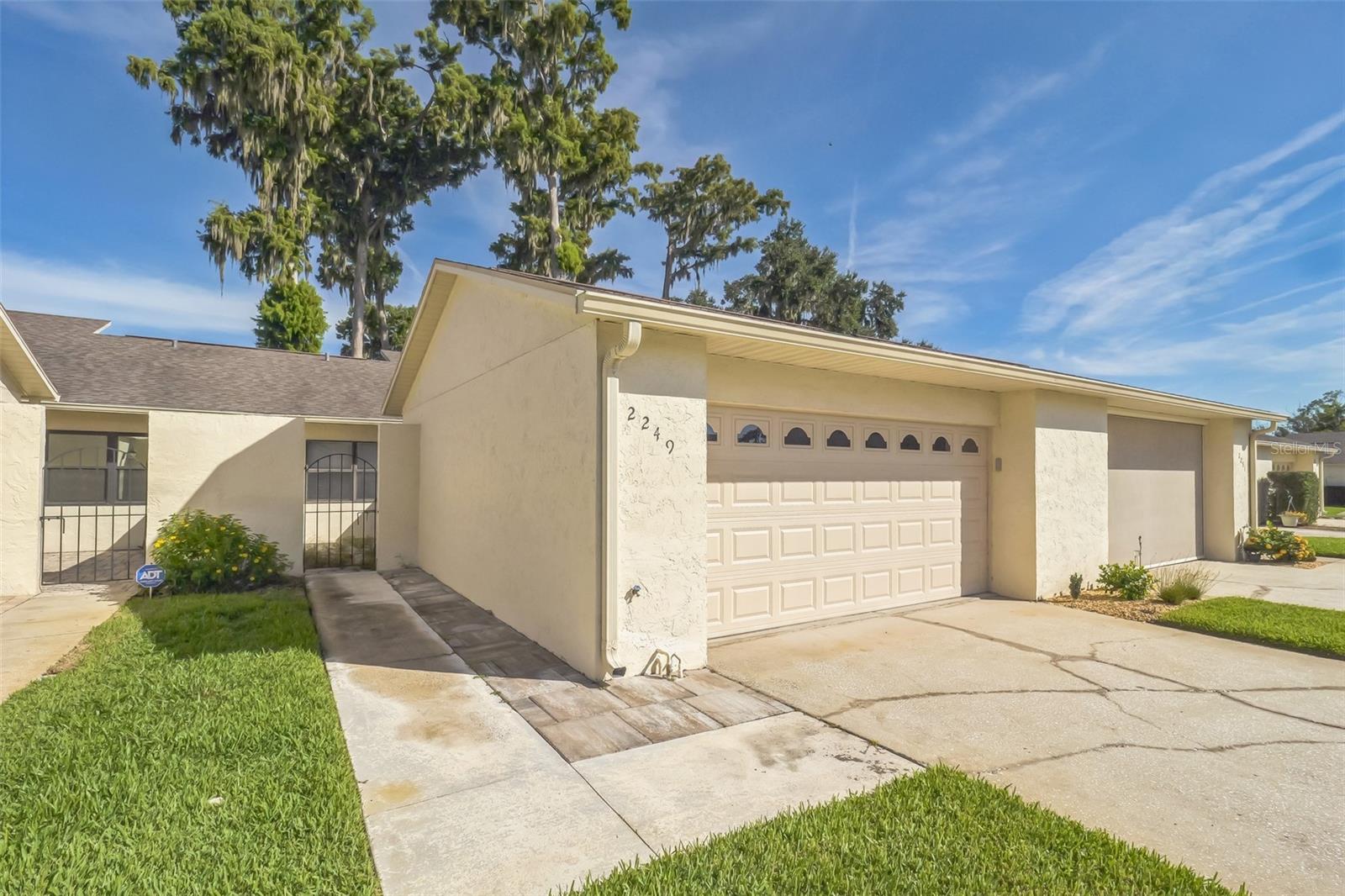 Enjoy a stunning lake view from this centrally located condo, just steps from the pool. This home features tile flooring in excellent condition, a brand new glass door, and an oversized 2-car attached garage. The kitchen and bathrooms are a great opportunity for personalization. With a central electric heating and cooling system, this condo is ready for you to make it your own.