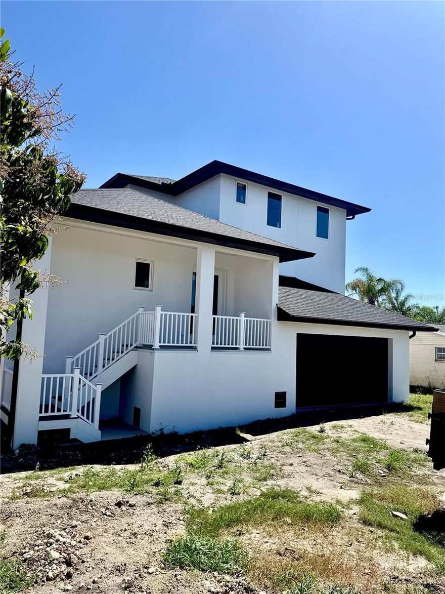 Under Construction. Welcome to 9832 Island Harbor Dr, a brand-new 3 story luxury waterfront home in the heart of Port Richey, FL, where modern design meets coastal living. This 4 bedroom, 3.5 bathroom residence is built with strength, style, and sophistication, offering direct Gulf access for boaters and sunset enthusiasts alike. Solid cell block on floors 1 and 2. Inside, the spacious master suite impresses with dual walk-in closets, tray ceilings, and a spa-worthy bathroom featuring a freestanding soaking tub, frameless glass shower with rain head and wand, and dual vanities. The chef’s kitchen boasts white shaker cabinetry, quartz countertops, Samsung Bespoke appliances, and soft-close details, while French oak luxury vinyl floors, custom tile work, 8-foot solid core doors, dimmable recessed lighting, and a White Oak staircase create an elevated sense of elegance throughout. Every detail was designed for comfort and peace of mind, from impact-rated top of the line PGT windows, 11 foot ceilings, to spray foam insulation, energy-efficient HVAC, and ethernet in every room with a smart thermostat for modern convenience. A screened-in lanai with recessed lighting and fans overlooks the water, creating the perfect setting for outdoor living and entertaining. Beyond the home, Port Richey’s Nature Coast location offers quick boating access to the Gulf, waterfront dining, marinas, and small-town charm, all just a short drive from Tampa and Clearwater. Combining style, durability, and location, this home offers the very best of Florida waterfront living.