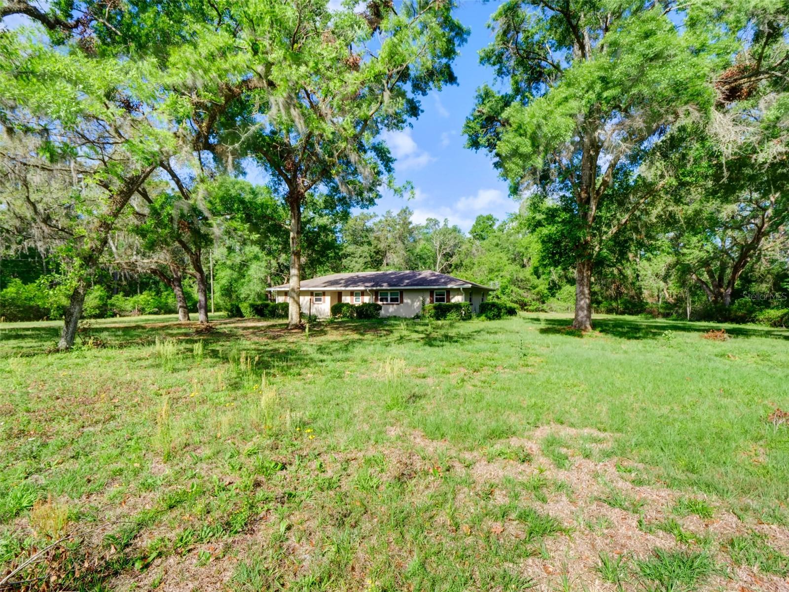 Discover Your Private 5-Acre Escape in the Heart of Central Florida. Picture yourself retreating to your own private wooded sanctuary, where five fully-fenced acres of natural beauty provide the perfect backdrop for peaceful living just minutes from everywhere you need to be. This exceptional Bushnell property offers you something increasingly rare in today's market—true privacy and space, set back from the road among towering trees that create your own natural fortress of tranquility. While the home awaits your personal vision and improvements, you're already ahead of the game with approximately $20,000 in recent upgrades including a four-year-old roof and newer A/C system, meaning the major expenses are behind you, not ahead of you. Whether you're envisioning a peaceful family retreat where kids and pets can roam freely, planning a smart investment in Central Florida's growing market, or dreaming of your own private homestead complete with space for livestock and outdoor adventures, this property delivers on every level. The location couldn't be more strategic—you'll enjoy the serenity of rural living while staying connected to the world with quick access to I-75, US 301, the Florida Turnpike, and Highway 44, putting Orlando, Tampa, and the Gulf Coast all within easy reach. This is more than just a property purchase; it's your opportunity to secure a lifestyle that combines the best of privacy, potential, and convenience at a price that reflects today's market reality. Properties offering this much land, privacy, and location advantages are becoming increasingly scarce in Central Florida's expanding landscape, making this your chance to claim your piece of paradise before it's gone.