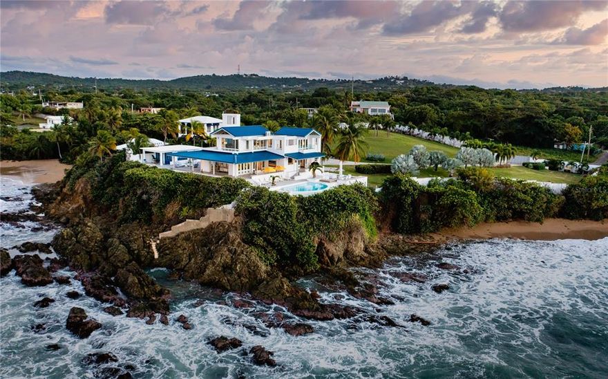 Serenity Point is a RARE and majestic oceanfront estate located cliffside in Monte Santo Playa on Vieques Island.  Designed by the well known New York and San Juan prestigious firm Marvel Architects, the home is positioned to capture sunset views over El Yunque tropical rain forest.  There is not a more sophisticated, unique, and private setting on the water in Puerto Rico.   Vieques Island is 20 minutes from San Juan via commercial or private plane or land your helicopter on the sweeping lawn.   Vieques is the new hot spot to escape to and truly find your Serenity! 

Serenity Point offers extreme privacy on one acre with an access controlled gated entrance and winding,  palm lined drive. The home features an infinity, cliffside swimming pool with a front row seat to the clear blue sea stretching out in front of you.  Professionally landscaped with a variety of outdoor entertaining areas including a gas fire pit and featuring Italian designed furniture.  Alfresco living is raised to an art form at Serenity Point!   There is high speed internet throughout  the property.

The front door opens to a custom furnished living room surrounded by glass with breathtaking ocean views.  Luxury finishes throughout the home including a recessed Jean Paul Gautier for Roche Bobois furnished living room.  Throughout the home there are high ceilings, air conditioning, a custom designed Nautilus shell inspired stairway, automatic Lutron shades throughout the home with additional blackout shades in the bedrooms, recessed lights, video security system, integrated Hue lighting system and a laundry with two sets of washer/dryers.   Roche Bobois and Mitchell Gold furnishings throughout and carpets from ABC Carpet and Home.

The home features five bedrooms and five and one half bathrooms across multiple structures affording extreme privacy.  Each bedroom offers stunning water views from the guest casita with en suite and kitchenette and a two bedroom apartment with an en suite and a full kitchen.  All of the bedrooms have walk in closets.

The modern eat-in custom kitchen features abundant storage, quartz countertops, and a suite of high end appliances including GE Monogram refrigerator/freezer, oven and stove, and integrated dishwasher.  There is a full bathroom off the kitchen with both having easy access to the pool area.

One of the secret surprises of this home is natural "grotto" salt water swimming pool accessed by a narrow, hidden stairway.   There is beach access with the best snorkeling and  diving on the island.  The home has a back up power generator and back up cistern water storage.  There are expansive water views from every room in the house and vantage point with photos unable to truly capture this one of a kind home.  Serenity Point is turnkey and must be seen in person to experience the essence.

Serenity Point has been lovingly cared for and curated by it's owner and has never been a rental or AirBnB.