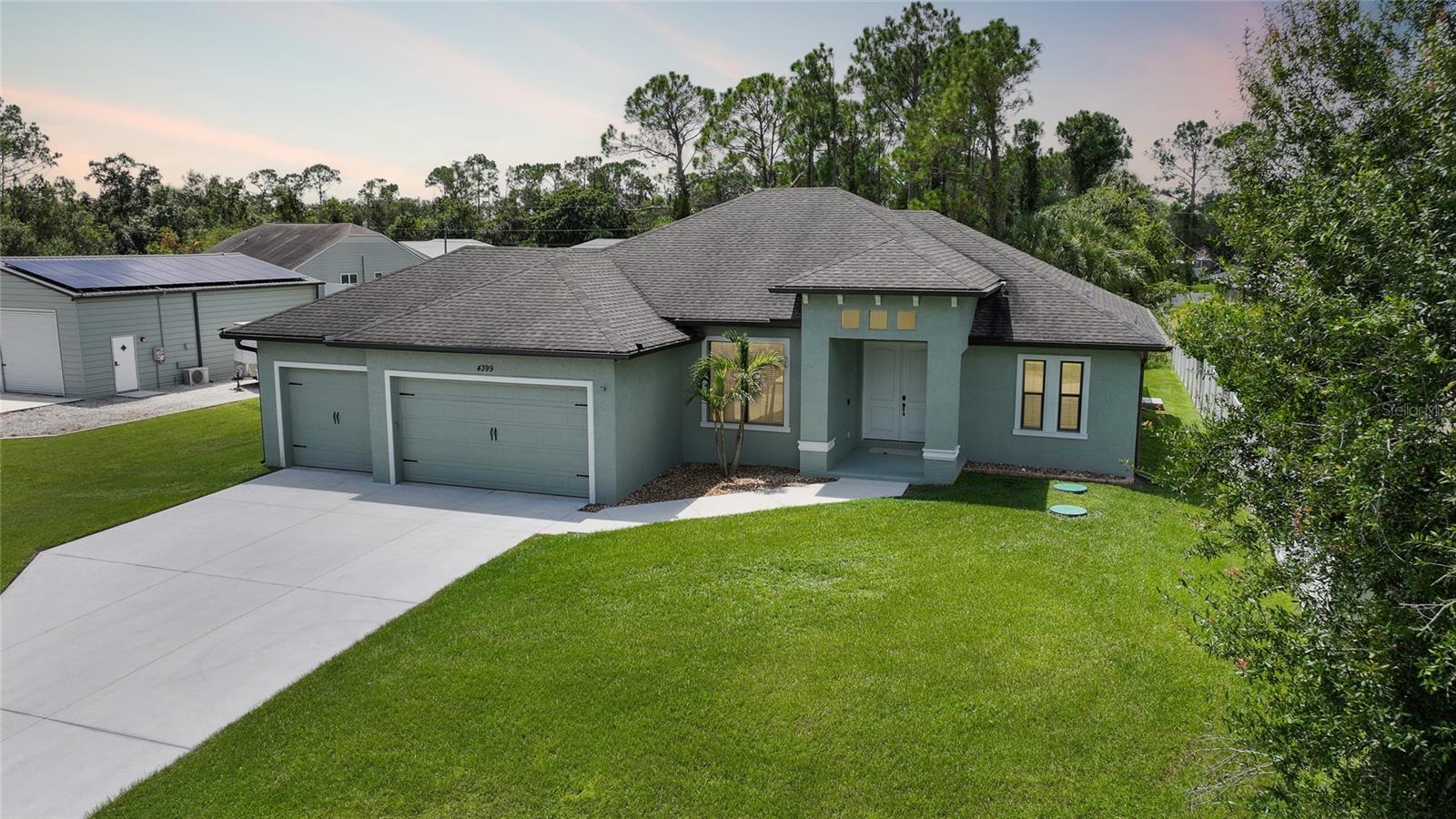 ***TURNKEY FURNISHED*** Harness the sun and enjoy complete energy independence in this solar-powered sanctuary. Designed for those who live big and dream bigger, this stunning 3-bedroom, 2-bath, 3-car garage home was built in 2020 and sits on an oversized double lot. In addition to the attached garage, the property includes a 30x40 detached garage/workshop with double doors, full insulation, and air conditioning—perfect for boat storage, a home business, or your ultimate workshop. Enjoy Florida living year-round in the heated pool with a screened lanai, ideal for relaxing, entertaining, or soaking up the sun in total comfort and privacy. There’s plenty of parking and space for all your recreational vehicles and gear. The home features an open-concept, split-bedroom floor plan with beautiful porcelain plank tile flooring throughout, creating a sleek and modern living space. Added comforts include a whole-home reverse osmosis water system, ensuring pure, clean water from every tap. What truly sets this property apart is its advanced 44-panel solar power system paired with three Tesla Powerwall batteries, offering full off-grid capability for sustainable, energy-efficient living. Whether you’re entertaining guests, tackling your next project, or simply relaxing in your energy-independent haven, this home has it all.