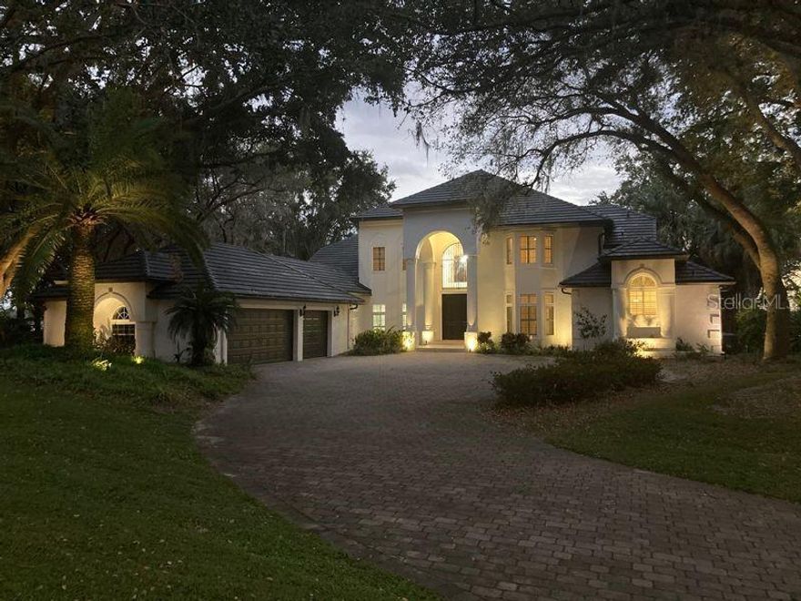 Beautiful Windermere Chain of Lakes Estate.. This Lake Down waterfront two story custom home consists of (4 Bedrooms plus Office).
Located on two incredible acres of lakefront with spectacular views of the fabulous Lake Butler Chain of Lakes.
Upon entering the home you are greeted to a wonderful view of the lake through the two story cathedral windows in the grand living area with large stone fireplace. Large chef style kitchen with cooking island and large counter tops overlooking the gracious backyard.
First floor large master suite with French doors leading out to the resort style pool, spa and outdoor sitting area with fireplace.
With over 4000 sqft. of Travertine flooring makes this the perfect home for lakefront living.
There is a Large bonus room with fireplace for added entertainment.
Upstairs consists of three large bedrooms with high ceilings and fans.
Property comes with a Covered dock w/boat hoist allowing you to enjoy one of Florida’s finest fresh water chain of lakes.
Come enjoy the life style... Room Feature: Linen Closet In Bath (Primary Bathroom).