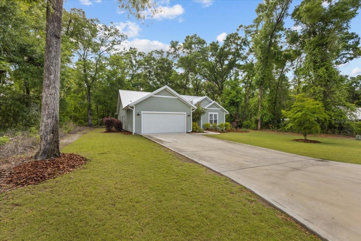 Welcome to this pristine like-new 3-bedroom, 2-bath home in the sought-after gated community of Riverwalk of Fanning Springs. With over 1,800 sq ft of thoughtfully designed living space on a spacious 0.37-acre lot, this home is a true showcase of pride in ownership. Step inside to discover an open floor plan featuring luxury vinyl plank flooring throughout. Large kitchen with quartz countertops, stainless steel appliances, a generous island, charming coffee bar, and an impressive walk-in pantry. The split-bedroom layout provides privacy and functionality, highlighted by a luxurious master retreat with a tray ceiling, oversized walk-in closet, and spa-like en-suite bath complete with dual vanities, a private water closet, and a beautifully tiled walk-in shower. Additional features include a convenient drop zone, a spacious laundry room with charming custom sink, plantation shutters throughout, and a 2-car garage. Enjoy peaceful mornings or relaxing evenings on the screened-in back porch overlooking the tranquil community green space. This home is built to last with a metal roof, full gutter system, and a long concrete driveway. Riverwalk’s resort-style amenities include a 6,000+/- sq ft clubhouse, fitness center, sparkling pool, tennis courts, sauna, and scenic paved walking/biking trails that connect directly to the Nature Coast State Trail—perfect for exploring all the way to the Suwannee River. A perfect blend of comfort, style, and lifestyle—this home truly has it all