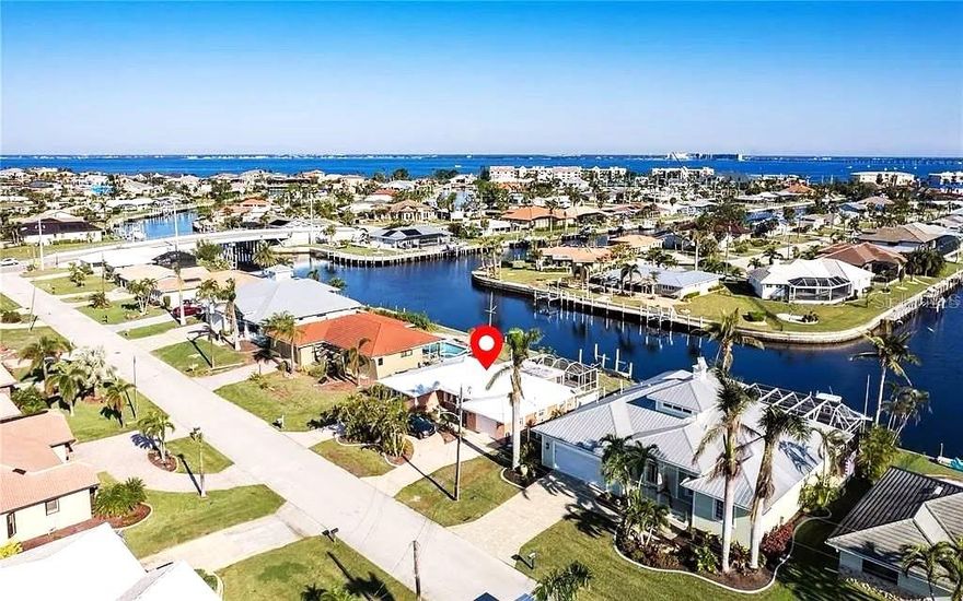 PUNTA GORDA ISLES WATERFRONT GEM!
Live the ultimate Southwest Florida boating lifestyle in this beautifully updated 3-bedroom, 2-bath waterfront home offering just 10 minutes in and out to open water — giving you quick access to Charlotte Harbor and the Gulf of Mexico! Featuring 80 feet of waterfront, intersecting canal views, concrete seawall, private dock, and boat lift, this property is a true boater’s paradise.

Step inside to discover a bright, open layout with tile flooring throughout, crown molding, and elegant spaces perfect for entertaining. The modern kitchen boasts granite countertops, custom wood cabinetry, stainless-steel appliances, and a breakfast bar pass-through to a flexible bonus room ideal for dining or a family room.

The primary suite offers a private bath, walk-in California closet, and access to a fenced side yard—a quiet retreat for morning coffee or evening relaxation. Guests enjoy privacy with the split-bedroom floor plan, generous guest rooms, and a full bath.

Outdoors, enjoy year-round living on your large screened lanai, surrounded by lush tropical landscaping and two fenced areas—perfect for pets or gardening. Additional highlights include a metal roof, impact windows, circular driveway, and a 1-car air-conditioned garage. A/C replaced in 2018.

Ideally located in the heart of Punta Gorda Isles, a world-class boating and golf community, just minutes to the Yacht Club, Fishermen’s Village, and historic downtown Punta Gorda with its dining, boutique shopping, and vibrant waterfront entertainment. Convenient to I-75 and the beautiful Gulf beaches of Southwest Florida.

Move-in ready, perfectly maintained, and offering fast open-water access — your dream waterfront home.  MORE PHOTOS ARE COMMING SOON!