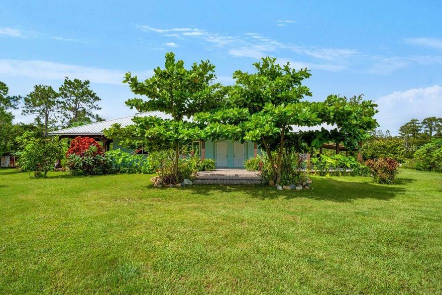 Welcome to Your Florida Country Retreat!
Discover the perfect blend of comfort, style, and freedom in this stunning 2-bedroom, 2-bath home with an office/den that can easily convert into a third bedroom. Offering over 1,700 sq. ft. of thoughtfully designed living space, this home invites you to experience the best of Florida country living — with all the modern touches you love.  Step inside to find high 9’ ceilings throughout opening up to a cathedral ceiling in the great room, decorative fixtures, and high-end cork flooring throughout. The home’s open-concept design brings light and warmth into every corner, enhanced by energy-efficient triple sliding glass doors that seamlessly connect indoor living with the beauty of the outdoors.  The gourmet kitchen is a chef’s dream — featuring upgraded KitchenAid appliances, a built-in induction cooktop, separate wall oven, and a spacious bar that opens to the bright living and dining areas. Perfect for entertaining or cozy family gatherings.  Retreat to the large primary suite, complete with its own triple sliders to the patio, dual ceiling fans, and a spa-inspired bath featuring an accessible walk-in shower with bench, Moen fixtures, and a massive walk-in closet.  A private utility room with washer/dryer hookups and a separate exterior entrance adds everyday convenience, while a tankless water heater ensures efficiency and comfort year-round.  Outside, enjoy over 5 acres of peaceful countryside views from your wraparound porch, pre-wired for speakers and future expansion. Zoned for residential and agricultural use, this property is ideal for anyone dreaming of a self-sustaining homestead. Bring your animals — there’s a chicken coop, livestock and horse pens, an irrigated garden, and even a private pond stocked with bass and tilapia.  Many planted fruit trees — almond, loquat, avocado, mango, and cherry — dot the landscape, creating a lush, private oasis where nature and comfort meet. A short stroll along the creek leads to a 1,500-acre hiking trail, perfect for peaceful morning walks or weekend adventures.  Tucked away with no rear neighbors, this home offers rare tranquility and privacy, yet it’s still close to everything — just 45 minutes from Orlando’s world-famous attractions and 30 minutes from Kennedy Space Center, beaches, and cruise ports.  This move-in-ready haven combines modern accessibility, thoughtful design, and the true spirit of Florida living. Come experience the comfort, freedom, and charm of country life — this is the home you’ve been waiting for.