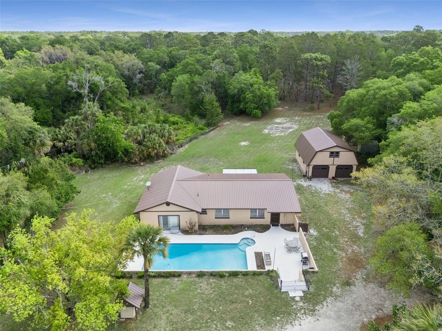 Welcome to Country Living at its finest! This spacious 4-bedroom, 2-bath single-family pool home sits on just over 3.4 acres in the sought-after Geneva Bubble  area, offering the perfect blend of privacy, space, and convenience.NO HOA! Step inside to an open floor plan featuring large, flexible rooms—ideal for families and entertaining. The welcoming living room flows into a formal dining area, which connects seamlessly to the kitchen and overlooks the tranquil Florida room. Enjoy your morning coffee surrounded by views of the secluded, wooded backyard, where wildlife and peaceful nature walks await.

Retreat to an expansive primary suite with a private bath, complete with both tub and shower. Three additional bedrooms and a second full bath provide plenty of space for family or guests. Outdoor living shines here: take a refreshing dip in the newly resurfaced pool, relax under the two-car carport, or explore the separate two-story, two-car garage/barn with electricity—a dream space for car collectors, workshops, or even an upstairs apartment or in-law suite.

With no HOA, A5 zoning, and 227 feet of road frontage, the possibilities for home, business, or hobby pursuits are endless. Recent updates include a new metal roof, replumbed plumbing, new AC, and a serviced well. Enjoy quick access to top schools, East Coast beaches, UCF, Lake Mary, and Sanford—plus, imagine watching the Rocket launches from your backyard. Experience the best of Florida country living, all while staying close to everything you need!