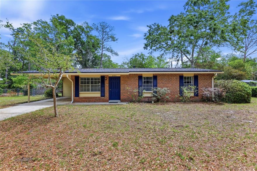 One or more photo(s) has been virtually staged. Welcome home to this charming 3 bedroom, 2 bathroom, 1,249 sq ft home in Hazel Heights, offering classic curb appeal, thoughtful updates including a NEW ROOF and NEW HVAC in 2026, and a spacious 0.25-acre lot perfect for everyday living and weekend relaxation. The beautiful brick exterior creates a timeless first impression as you arrive, and the covered carport offers convenient, weather-protected parking. Step inside to the light and bright flexible entry space that can serve as a living room, dining room, or play space for the children. Currently used as a dining room, this area is bright and welcoming, with a large window that fills the space with natural light, ideal for family meals or hosting friends. The wood-look tile floors add character and flow seamlessly throughout the main living areas and bedrooms (no carpet). Moving through the home, you’ll find a well-appointed kitchen featuring solid wood cabinetry, a pantry for extra storage, a gas stove, and and plenty of counter space for meal prep and cooking. Past the kitchen you’ll step into the inviting family room, where the vaulted ceiling with an exposed beam and the stone fireplace create a cozy and airy gathering space. Three bedrooms are located down the hallway. The primary bedroom is at the back of the home with a fully updated ensuite bathroom featuring a new vanity and tiled walk-in shower. Two guest bedrooms feature ample closet space. The hall bathroom has an updated vanity and tub-shower combo. Enjoy year-round indoor–outdoor living with a screened-in porch overlooking the expansive fenced backyard. With plenty of room to play, garden, or unwind around the built-in fire pit, this outdoor space is ready for quiet evenings or lively get-togethers. Fiber optic internet ensures you have high speed connectivity whether working from home or streaming your favorite shows. A new roof and new HVAC make this home turn-key for the new homeowner. This home is centrally located in NW Gainesville, in a beloved neighborhood with NO HOA, with quick access to everyday conveniences. You’re just minutes from Publix, UF, Santa Fe College, and a variety of shopping and dining options along NW 39th Ave and NW 13th St. Commuting is simple with multiple RTS bus stops nearby. Schedule your private showing today!