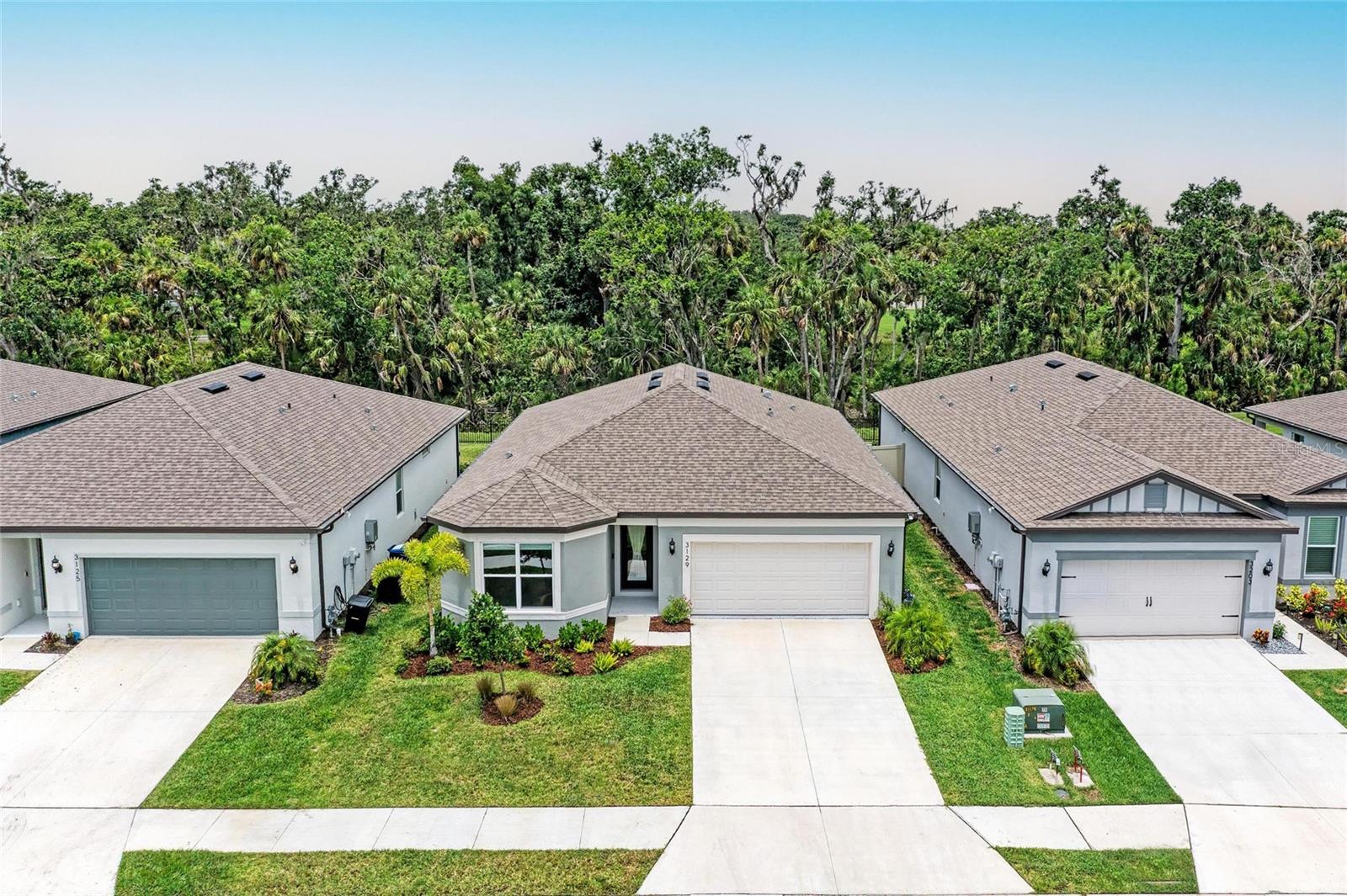 Seller offering up to 2.5% toward buyer’s closing costs, prepaids, or interest rate buy-down with acceptable offer and lender approval.
This 2024-built, 3-bedroom, 2-bathroom home offers more than just upgraded finishes—it delivers architectural detail, curated design, and thoughtful luxury at every turn. A fully fenced yard provides privacy and security, while easy-install hurricane shutters offer peace of mind during storm season. Step inside to a striking, floor-to-ceiling custom drop zone with integrated lighting, setting the tone for a home where form meets function. Just off the entry, a dedicated home office features wall-to-wall shelving and a solid wood desk, offering versatile space for books, décor, and creativity—perfect for focused work or artistic inspiration. Nearby, the guest bathroom continues the custom design story with a floating vanity wrapped in waterfall quartz, accented by rich slatted wood paneling and gold fixtures that lend a hotel-style charm and elevate the space. The kitchen is a true showpiece, blending style and efficiency with quartz countertops, a herringbone tile backsplash, soft-close cabinetry, brass hardware, statement pendant lighting, and under/above-cabinet illumination. The adjoining dining area is framed by sliding glass doors for seamless indoor-outdoor flow and anchored by a sculptural mid-century chandelier that adds warmth and personality. The living room is elevated by a bespoke media wall with floating cabinetry, flanked by vertical, true wood slats that add natural texture and depth—creating a bold, architectural centerpiece. In the primary suite, enjoy boutique-inspired comfort with a floating makeup vanity, custom-built nightstands, a minimalist floating headboard, and ambient pendant lighting. A fully built-out walk-in closet offers tailored storage, while the ensuite bath includes dual quartz vanities, organic-shaped mirrors, and a recessed storage nook with dark-stained floating shelves. Located in a boutique community of just 70 homes with no CDD, this residence combines upscale design with everyday convenience. I-75 is just around the corner, and you're within walking distance to Ellenton Premium Outlets—putting shopping, dining, and easy commuting right at your doorstep.