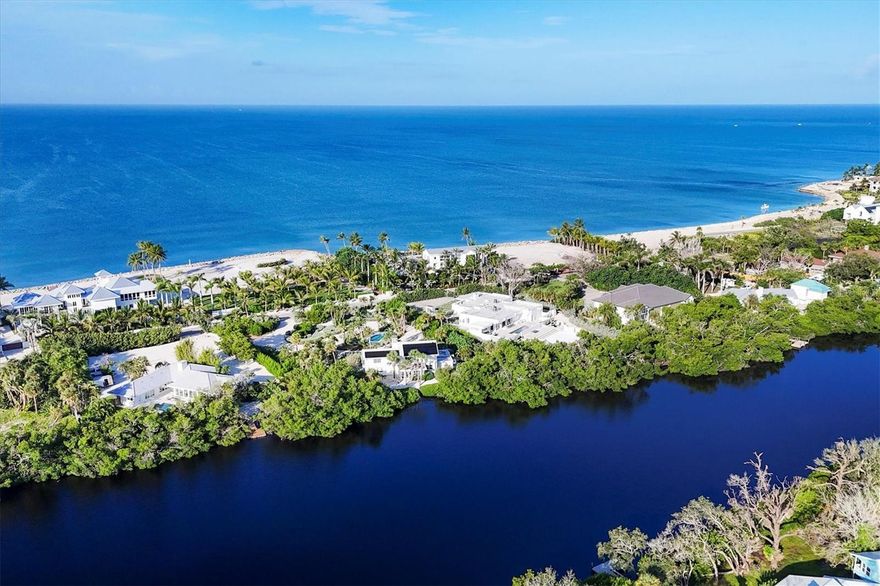 Photos 1–3 showcase preliminary renderings of a proposed architectural concept for this exceptional property. Envisioned as a modern coastal retreat, the design celebrates the relaxed luxury of mid-century architecture while maximizing the natural beauty of its surroundings. This residence is a modern coastal retreat set on over an acre and blends luxury with the charm of mid-century design. Enjoy the property just as it is or explore the endless possibilities for building your dream home or compound to take advantage of endless water and sunsets views. This residence greets you with an expansive circular shell stone driveway, offering a grand approach to the home. Upon arrival, you’re welcomed into an open entryway that flows into the main living areas. The living room offers a relaxed setting with terrazzo floors, built-in shelving, a large picture window, and a cozy fireplace framed by shiplap accent walls. Tri-fold glass doors open to a bright Florida room, also with terrazzo floors, creating seamless indoor-outdoor living. A distinctive concrete wall separates the space from the dining area with built-in bar seating. The kitchen features custom soft-close cabinetry, quartzite countertops, and Bosch appliances—including a gas cooktop, oven, refrigerator, and dishwasher—framed by large windows with peaceful lagoon views. Outside, enjoy a shell-crete pool deck with ample room for lounging and dining. A heated pool, shuffleboard court, and firepit seating area complete the inviting outdoor space. Upstairs, a flexible bonus room includes built-in closets, water-view windows, and a full bath with a tub/shower, vanity, and stylish tile. Step out to the rooftop deck with panoramic views of the pool, grounds, and Heron Lagoon. The primary suite offers high beamed ceilings, shell-crete floors, sliding glass doors to a private lagoon-view deck, and an en-suite bath with a floating dual-sink vanity, glass walk-in shower, private water closet, and linen closet. A custom walk-in closet with built-ins and soft-close drawers completes the suite. Two guest bedrooms, a full guest bath, a butler’s pantry, spacious laundry room, and half bath round out the main level. Despite being impacted by the 2024 hurricanes, the house and property have recovered quickly. The Sanderling Club has released renderings that envision a new era for its historic clubhouse and private waterfront setting. The Miami-based architectural firm STRANG has designed a new residence for the expansive site.  The elevated design highlights the opportunity for tremendous Gulf views.  The property’s unique setting amidst Heron Lagoon and the Gulf of Mexico allows for stunning vistas of sunrises and sunsets. This property is one of the largest lots on Heron Lagoon in Sanderling – prime for redevelopment as it would offer amazing views and is large enough to accommodate a significant home/compound. The property is located minutes from Siesta Key’s crystal quartz sand beaches and Siesta Village for shopping and restaurants. Culturally rich downtown Sarasota restaurants, theater, ballet, opera, museums, galleries, and shopping are a short drive away.