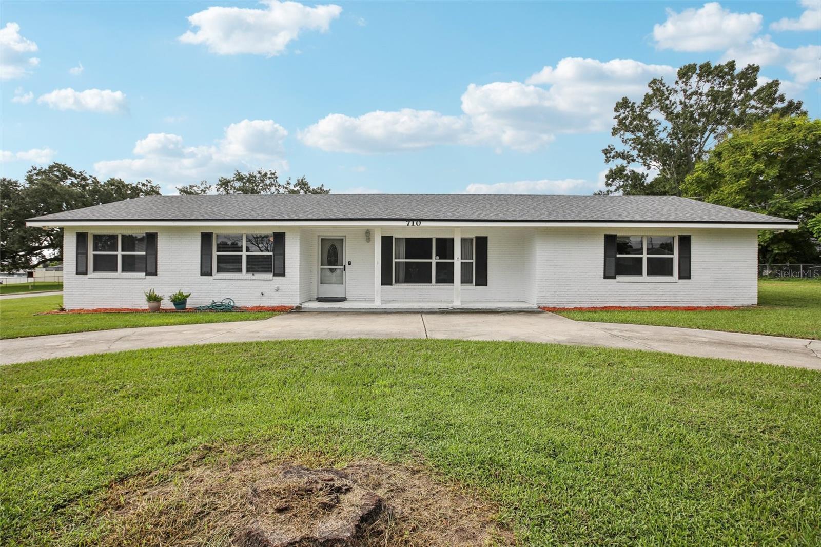 Welcome to this beautifully updated four-bedroom, two-bathroom home, offering just over 2,000 square feet of comfortable living. Situated on a spacious corner lot with a convenient circular driveway, this offers wonderful curb appeal. Inside, you'll find wood-look tile flooring throughout the expansive living areas, freshly painted walls, newer roof and a thoughtfully designed eat-in kitchen complete with counter seating and sleek stainless steel appliances. The primary bedroom features a private ensuite, while two other generously sized bedrooms share an updated hall bath with a tiled walk-in shower.
Step outside through the sliding doors to a covered and enclosed lanai, perfect for enjoying the Florida weather. The attached carport provides additional covered space that could easily double as an extra entertaining area. With two exterior sheds and an additional indoor utility room, this home has no shortage of storage. Conveniently located and move-in ready, this is a must-see! Schedule your private showing today!