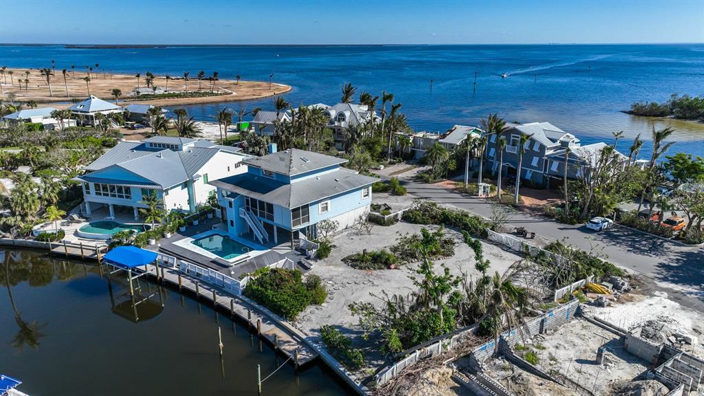 This prime property is located on desirable Harbor Drive in the Waterways district of the charming Village of Boca Grande. The home features beautiful views of the Bayou, an inground pool, a newer dock and covered lift. The home suffered damage from hurricane Ian and is being sold "AS-IS". You can renovate to suit your needs. The front of the property has Eastern exposure that will allow you to enjoy views of the morning sunrise over Charlotte Harbor from the deck. The rear of the property and pool have Western exposure, so you can take in the colorful sky as the sun goes down. Once in lifetime location!