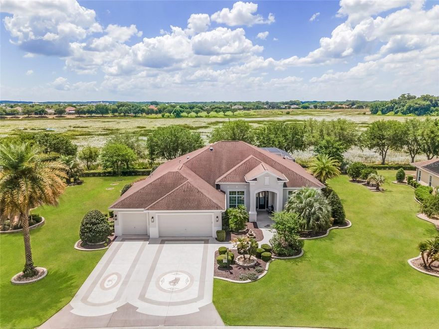 Discover a RARE OPPORTUNITY to own a “SLICE OF PARADISE” in the prestigious VILLAGE of BRIDGEPORT at LAUREL VALLEY near Lake Sumter Landing & CR 466! This exquisite ST. CHARLES III PREMIER home, one of only nine w/ a waterfront view of the Miona Prairie Preserve, exemplifies ultimate LUXURY & PRIVACY. Built on a generous half-acre lot, which commanded a $200,000 premium at purchase in 2011, this property has been well maintained by its ORIGINAL OWNER. This gorgeous 3,018 sf home features a flowing OPEN CONCEPT w/ SPLIT BR floor plan consisting of 3 BR/ 3BA/ extended 3 Car Garage (4’ stretch totaling 1200 sf)! Professionally redesigned in 2022, key upgrades included new kitchen & bathroom cabinets, extensive custom woodworking, updated ceiling lighting indoors & out, new plumbing fixtures, & fresh interior/exterior paint. The CURB APPEAL is enhanced by artistically textured concrete finish on the DRIVEWAY & WALKWAY, professionally designed landscaping & outdoor lighting w/ new rock-filled beds & stacked stone hardscaping plus a welcoming front door with ¾ length LEADED GLASS detail. When you step inside the FOYER, you will be awe-struck by quality finishes throughout the home - towering 12‘ ceilings in main LA, CROWN MOLDING, 5¼“ baseboards, DIAGONAL SET, LARGE TILE FLOORING, specialty woodworking finishes over all windows & doors, wood blinds, octagonal TRAY CEILINGS trimmed w/ wood molding & lighting in the formal DR & LR, custom WOOD PANELING & woodworking in 3 rooms, and TRANSOM WINDOWS over two sets of SLIDING GLASS DOORS that provide sight lines through the expansive OUTDOOR OASIS to the serene PRESERVE VIEW. Pristine TRAVERTINE TILE extends throughout the 45’ x  24’ COVERED LANAI & into the huge LED lighted MANSARD SCREENED POOL ENCLOSURE (rescreen 2021) w/ majestic columns. This OUTDOOR LIVING space boasts a custom designed SALTWATER, HEATED (gas & electric) SWIMMING POOL w/ several elegant water features, a Baja shelf, an in-pool granite side table w/ umbrella, & an adjoining JETTED SPA. Add’l highlights include a CUSTOM-BUILT FIRE PIT, a SUMMER KITCHEN, & easy access to POOL BATH. Entertaining will be a breeze! Back inside, the gourmet KITCHEN features white SHAKER STYLE cabinets w/ UNDER LIGHTING, PULL OUTS in lower cabs, gleaming GRANITE COUNTERTOPS, ISLAND workspace, chic TILE BACKSPLASH, and upper-end SS APPLIANCES, including a GAS STOVETOP & WINE REFRIGERATOR. The LAUNDRY ROOM is adjacent to the kitchen. The PRIMARY BEDROOM is perfectly situated for sunrise views of the Preserve & abundant NATURAL LIGHT. This haven sports 12’ ceilings, double FRENCH doors to the lanai, 2 CUSTOM CLOSETS, & an ENSUITE BATH w/ dual sinks/vanity, private water closet, jetted TUB, & tiled ROMAN SHOWER. Moving to the GUEST WING, BR 3 (front) flaunts 12’ ceilings, built-in desk & cabinets, a CUSTOM CLOSET, & an adjacent BATHROOM 2 featuring a tiled TUB/SHOWER combo. BEDROOM 2 (back) features an ENSUITE POOL BATH (3rd BA).  Add’l perks include: Room to expand on both sides of home, smartphone control of dual zone HVAC & irrigation system, FTTC fiber internet, EPOXY garage floor, ATTIC PULL DOWN STAIRS, WATER SOFTENER, & buried PROPANE TANK. Surrounded by panoramic views of the nature preserve, this PERSONAL SANCTUARY offers a life of unparalleled comfort & serenity combined w/ the unmatched VILLAGES LIFESTYLE! Designer TURNKEY pkg & 2 golf carts available separately! Call now for a private showing! BOND BALANCE ~ $36,112
