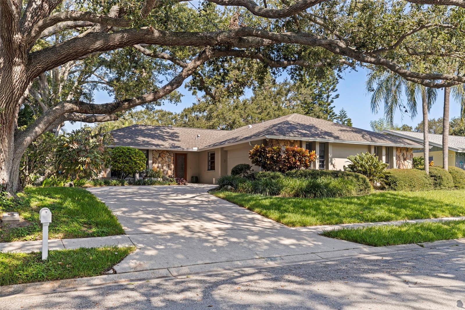 What a showstopper! This beautifully updated 4 bed, 3 full bath POOL HOME combines comfort, style, and an unbeatable location. Just 5 minutes to Belleair Beach, top-tier dining, and shopping, this property was built with solid block construction and located in a NON FLOOD ZONE. Step inside to a bright, open-concept layout with a split floor plan, perfect for both privacy and functionality. Porcelain tile flows throughout—no carpet in sight! The chef's kitchen was thoughtfully designed, featuring quartz countertops, solid wood cabinetry, and a seamless flow into both formal and informal dining spaces. The spacious primary bedroom includes a walk-in closet, sliders that open directly to the pool area, and an ensuite bathroom with dual sinks and a walk-in shower. This home is perfect for entertaining with sliders in the kitchen and living room area that create seamless indoor-outdoor living, leading you to your private backyard retreat: a freshly resurfaced SALTWATER POOL with a screened enclosure, surrounded by mature tropical landscaping, outdoor lighting, and a flagstone patio with a propane fire pit. Whether you're hosting friends or unwinding after a long day, this yard is pure paradise. Additional features include a dedicated laundry room, vinyl privacy fence, sprinkler system, and updated mechanicals for peace of mind. This is Florida living at its finest—don’t miss the chance to call it home!