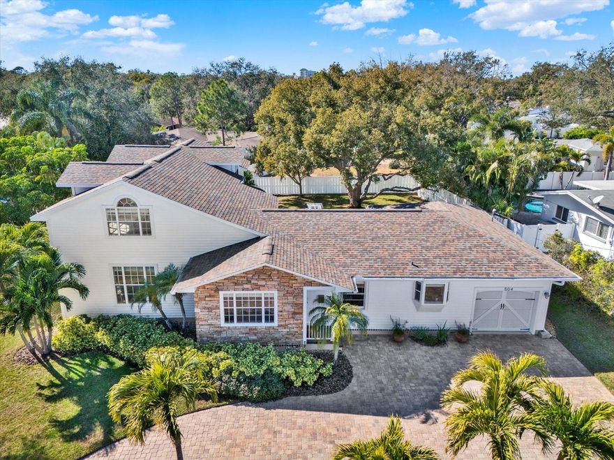 BEAUTIFULLY MAINTAINED BELLEAIR HOME SITUATED ON OVER 1/4 ACRE ON A LOW-TRAFFIC DEAD-END STREET! Exceptional curb appeal welcomes you with mature landscaping and a circular paver driveway. Offering 3,008 sq ft of living space, this 3BR/3BA residence with a dedicated office, bonus room, and interior laundry room blends timeless charm with thoughtful modern updates. The spacious living room, family room, and dining room provide ample space for both everyday living and entertaining. Gorgeous hardwood floors and abundant natural light enhance the warm and inviting atmosphere throughout. The gourmet kitchen is a chef’s dream, featuring granite countertops, stainless steel appliances, an attractive backsplash, and a convenient breakfast bar. The expansive primary suite includes a WALK-IN CLOSET with custom built fixtures, private access to the back deck, and a well-appointed bath with double-sink vanity, jetted tub, and walk-in shower. THE 1ST FLOOR ALSO OFFERS A SPACIOUS 2ND BEDROOM AND A PRIVATE OFFICE THAT COULD EASILY BE CONVERTED INTO A FOURTH BEDROOM IF DESIRED. Upstairs, you’ll find a 3rd bedroom, full bath, and an impressive bonus room with vaulted ceilings and a wet bar—perfect for a media room, playroom, or guest retreat. Enjoy outdoor living in a beautifully landscaped backyard with mature trees, a large deck, and an expansive yard with plenty of room to add a pool. Additional highlights include well-irrigated sprinkler system, water softener, surround sound speakers, dual HVAC systems, water heaters (2020), NEW ROOF IN 2020 and a shadow box vinyl fence. Conveniently located just minutes from Belleair Country Club, pristine beaches, shopping, and dining, this move-in-ready home offers space, comfort, and an unbeatable location.  NO FLOOD INSURANCE REQUIRED. Make your appointment to see this exceptional property today!