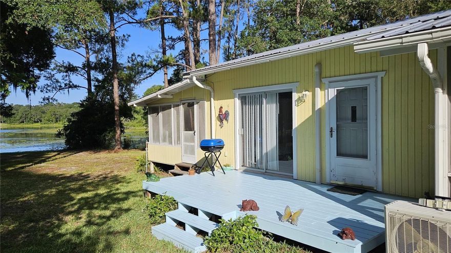 Crystal-clear waters of Lak-A-Wana Lake just a short drive from Gainesville/UF/Shands. This charming updated 2-bed, 1-bath cottage NOT IN A FLOOD ZONE offers breathtaking lake views, a peaceful shaded porch, and a spacious 3-acre lot. Metal roof, minisplit AC, septic, well, water filtration system, impact windows, flooring, wooden decks and cabinetry — all just 4 to 5 years old. Property includes a large chicken coop, two storage sheds, and even a golf cart for convenient rides around the grounds. Nature lovers will enjoy serene sunsets from the dock, abundant wildlife, and the fresh air of true lakeside living. Enjoy paved roads to your property & low Putnam County taxes. This property is perfect for gardening, raising chickens, goats, or simply going off the grid. Whether you're seeking a full-time residence or a weekend escape, this rare lakefront offering checks every box. Private lake access, separate meter for RV hookup, no HOA. REALTOR-FRIENDLY AND PRICED TO SELL!
