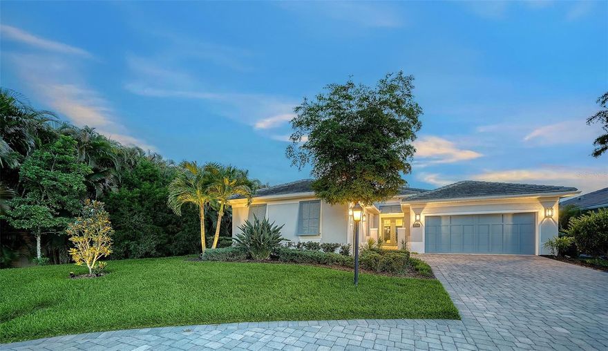 Welcome to a beautiful custom residence in Sandhill Lake, a boutique community of just 43 homes. This 2021 award-winning Magnolia model by Heritage is sited on a premium cul-de-sac lakefront homesite offering real peace of mind with 35 ft elevation, impact windows and doors, and low insurance cost.  As you enter, you are greeted in a refined foyer featuring custom architectural detailing. Next is the great room with a 13-foot tent ceiling creating a dramatic yet inviting focal point, anchored by Restoration Hardware chandeliers, a tiled fireplace, and expansive glass sliders framing serene water views. The chef’s state-of-the-art kitchen features custom floor to ceiling real-wood cabinetry, quartz countertops, an oversized island, high efficiency appliances, and a premium Wolf gas cooktop and oven. The primary suite offers soothing water views from a sitting area with wrap around windows. Two generous custom walk-in closets, an ensuite bath featuring an accessible walk-in shower, dual vanities, and European fixtures complete a spa-inspired experience. A thoughtfully designed floor plan ensures privacy, with guest accommodations in 2 bedrooms and a versatile den/flex space. Comfort is enhanced by a high-efficiency AC heat pump system and a fully integrated solar panel system. Step out of the sliders to your Florida sanctuary, featuring a private extended lanai, sparkling saltwater pool with waterfall, outdoor shower and kitchen, and tranquil lake views. Additional highlights include hardwood floors throughout and two separate garages offering ample space for 3 cars plus storage and EV outlets. The many premium extras in this home total over $200,000. Residents of Sandhill Lake enjoy a beautifully maintained clubhouse, resort-style pool, spa, and fire pit with low HOA fees which include lawn care and pest control, and no CDD. Ideally located in an A-rated school district and just minutes from world-class dining, shopping, golf courses, downtown Sarasota with cultural attractions, and the white sands of Siesta Key Beach. Opportunities like this in Sandhill Lake are rare—don't miss your chance to make this stunning home your own!
