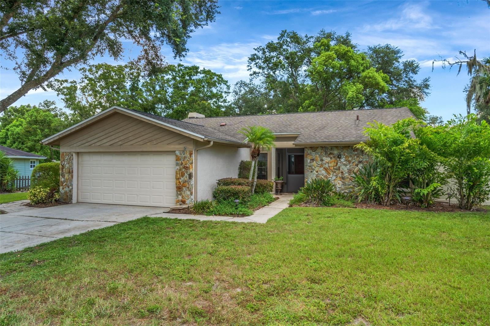 This wonderful home is a true tropical oasis! Situated on an oversized lot this home offers a special surprise. Just outside the screened lanai awaits a lagoon style pool with a real rock waterfall concealing a firepit behind all graced by over 2000 sf of pavers. The expansive yard is lined with Fishtailed palms and other Tropicals entirely enclosed by a new vinal fence that’s gated on both sides of the home. There's room here for boat or RV storage. This home showcases a beautiful designer kitchen that is the centerpiece of the spacious, open floor plan which greets you and your guest as you’re welcomed home. It’s a cook’s delight featuring ample granite counter space, an abundance of solid wood cabinets, a built-in desk and stainless appliances. The living area boasts a vaulted ceiling, wood burning fireplace and sliders opening to that incredible retreat that transports you to a tropical resort. The accommodating primary suite is just off the living area with sliders accessing the screened lanai and an ensuite bath with dual sinks, dual closets and tub with shower. Two more bedrooms and another full bath with a tub and shower complete this well-maintained home that’s waiting for you to make your own. This is Lutz living at its very best! Just outside of the busy City yet still close to absolutely everything. Life is more enjoyable when you come home to a beautiful neighborhood with NO HOA, NO CDD, not in a flood zone and everything this incredible home offers.