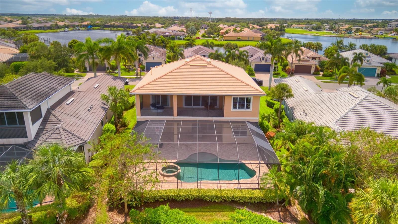 Spectacular coastal RIVERFRONT ESTATE commands endless water views. This gorgeous Savannah offers a modern spin on split-level living with stunning dual entry staircases opening up to a spacious foyer. The first level is perfect for a multi-gen family with 2 bedrooms, 2 bathrooms, and living area. Step through the sliders to one of the largest pools and lanais in the neighborhood. This massive 45x50ft, outdoor paradise space has new screens, outdoor kitchen hook-ups, and a huge 22x30ft cloud shaped, heated, pool with spa for entertaining all your loved ones. Also on the lower level, a laundry room with storage space and a 3-car split garage. Second level offers breathtaking river views of glistening water from every room that will “WOW” you. The open and inviting great room with tray ceiling and crown molding throughout has large sliders bring in natural light and leading to a second screened in lanai. Adjacent from the living room, a professional chef's kitchen with new refrigerator, SS appliances, gas cooktop, wall oven, oversized walk-in Butlers pantry, and granite island. Enjoy glorious mornings, breathtaking evenings, tropical breezes, manatees, dolphins & boats from this breathtaking vantage point. Around the corner, you enter a large office with built in bookshelves and large windows offering plenty of natural light. On the other side of the second level is the primary suite with walk-in closets and bathroom that includes large walk-in shower, water closet, and garden tub. This home is full of quality craftsmanship, fine finishes, and 2 new (2024) high efficiency A/Cs. Tidewater Preserve offers maintenance free resort-style living, a private marina, 2 clubhouses, resort-style pool, fitness center, community room w/kitchen, grill area, playground, dog park, canoe & kayak launch w/storage, and a full-time lifestyle director. Low HOA fees, NO CDD fee, and near world class beaches, shopping, and fine dining. Make your appointment to see this amazing home today!