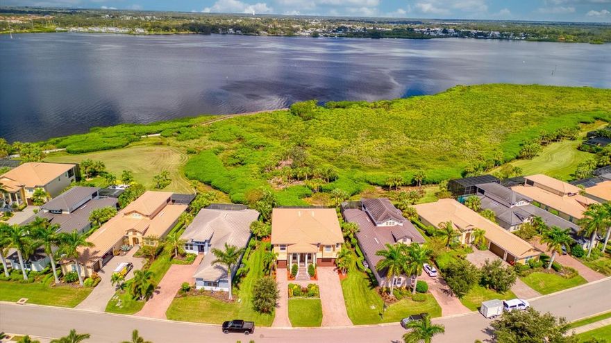 Spectacular coastal RIVERFRONT ESTATE commands endless water views. This gorgeous Savannah offers a modern spin on split-level living with stunning dual entry staircases opening up to a spacious foyer. The first level is perfect for a multi-gen family with 2 bedrooms, 2 bathrooms, and living area. Step through the sliders to one of the largest pools and lanais in the neighborhood. This massive 45x50ft, outdoor paradise space has new screens, outdoor kitchen hook-ups, and a huge 22x30ft cloud shaped, heated, pool with spa for entertaining all your loved ones. Also on the lower level, a laundry room with storage space and a 3-car split garage. Second level offers breathtaking river views of glistening water from every room that will “WOW” you. The open and inviting great room with tray ceiling and crown molding throughout has large sliders bring in natural light and leading to a second screened in lanai. Adjacent from the living room, a professional chef's kitchen with new refrigerator, SS appliances, gas cooktop, wall oven, oversized walk-in Butlers pantry, and granite island. Enjoy glorious mornings, breathtaking evenings, tropical breezes, manatees, dolphins & boats from this breathtaking vantage point. Around the corner, you enter a large office with built in bookshelves and large windows offering plenty of natural light. On the other side of the second level is the primary suite with walk-in closets and bathroom that includes large walk-in shower, water closet, and garden tub. This home is full of quality craftsmanship, fine finishes, and 2 new (2024) high efficiency A/Cs. Tidewater Preserve offers maintenance free resort-style living, a private marina, 2 clubhouses, resort-style pool, fitness center, community room w/kitchen, grill area, playground, dog park, canoe & kayak launch w/storage, and a full-time lifestyle director. Low HOA fees, NO CDD fee, and near world class beaches, shopping, and fine dining. Make your appointment to see this amazing home today!