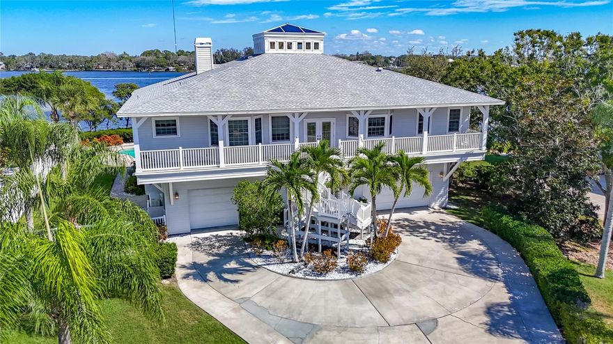 Discover a rare blend of coastal elegance, privacy, and modern design in this newly remodeled waterfront estate set on an elevated double lot along the scenic Anclote River. Built for both luxury living and resilience including a new roof in 2021, this home remained dry and undamaged through recent hurricanes, offering peace of mind and enduring value. 
Step inside to a bright, open-concept living area crowned by a lantern-style cupola that bathes the interior in natural light. Twelve-foot ceilings and expansive glass pocket doors create a seamless flow between indoor and outdoor living. The screened second-story veranda offers panoramic views of the tranquil cove and river—perfect for morning coffee or sunset gatherings by the cozy glass-front fireplace.
The spacious chef’s kitchen is equipped with premium Café Series appliances, including an Induction Café Series cooktop and Advantium Café Series built-in ovens, along with a Sub-Zero refrigerator, farmhouse sink, and striking black granite countertops reminiscent of river rock that complement custom cabinetry.
Retreat to the luxurious master suite upstairs, featuring an oversized his and hers closets and a fully remodeled spa-style bath with designer finishes.
Downstairs, a private mother-in-law suite includes a full kitchen, making it ideal for guests or multigenerational living. The four-car garage provides ample storage for vehicles, water toys, and more, while an elevator offers effortless access to all levels.
Step outside to enjoy lush tropical landscaping, a large paver sundeck, and a sparkling swimming pool overlooking the water. The new dock installed in 2021 features two lifts, fresh water and a fish cleaning station. Located just inside the mouth of the Anclote River, there is easy access to the Gulf, island beaches, and waterfront restaurants just minutes away.
Whether entertaining or unwinding in your own sanctuary, this home offers the best of Florida waterfront living—light, space, privacy, and luxury in every detail.
Additional upgrades include: new water heater 2023, reverse osmosis system with filter under kitchen Sink, and outdoor shed to convey.
