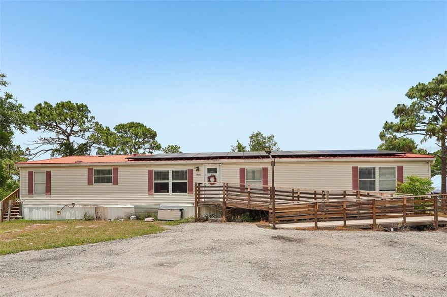 Set on nearly one acre of land, this spacious 5-bedroom, 2-bathroom double-wide manufactured home offers approximately 2,280 sq. ft. of versatile living space with no HOA. This property combines flexibility, comfort, and endless potential.

A standout feature of this property is the converted second family room, now designed to accommodate the 5th bedroom complete with its own private living area and kitchenette. With the option to add a separate entrance, this space offers excellent potential for a private in-law suite, guest quarters, or multigenerational living setup.

Outside, the fenced yard offers plenty of space to enjoy the outdoors. The property also features a circular driveway, two storage sheds, a covered workshop, and solar panels for added energy efficiency. The roof was replaced in December of 2017, offering added peace of mind for future homeowners.

Conveniently located with quick access to St. Cloud and Melbourne, this home offers peaceful surroundings while remaining close to shopping, dining, and major roadways. Nearby amenities include a community park with a playground, basketball court, walking trails, and picnic pavilions. This unique property offers space, functionality, and exceptional potential—ready for you to make it your own.