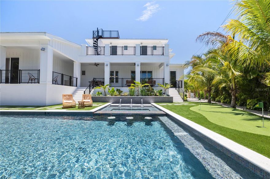 Welcome to this newly built Waterfront Home featuring a spacious 6 bedrooms, 6.5-baths with easy access to Bimini Bay and the Intracoastal Waterway from your private dock equipped with a 10,000 lb. boat lift. Positioned on a large corner lot just minutes from the beach this home is perfect for entertaining with surrounding water views from your private roof top terrace. The gourmet kitchen features a butlers pantry with wine cooler, custom cabinetry, quartz countertops, and high end appliances. The main floor master bedroom features a private patio leading to the pool plus walk-in closet. The spa-like master bathroom centers around your stand-alone tub and frameless glass shower with dual his and her vanities. All bedrooms are en suite with each bathroom having its own unique tile, countertop and vanity selection. A smart home system is included for your tv, speakers, and cameras. The private backyard features a large heated saltwater pool and spa with floating steps surrounded by lush landscaping and shell stone which also covers the lanai.  Call today for your private showing!