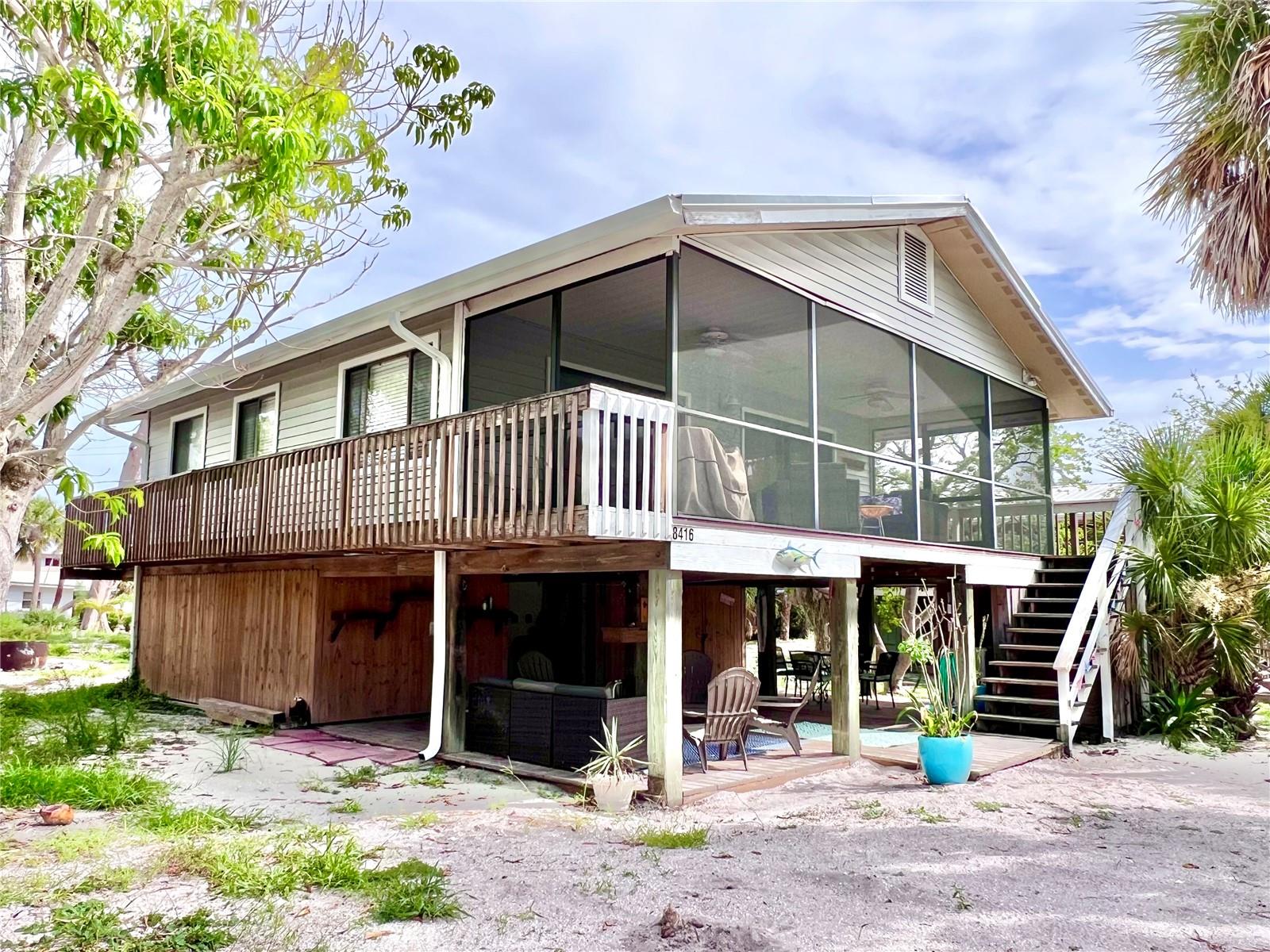 This 2-bedroom, 1-bath home on Little Gasparilla Island is third back from the bay and dock with views of the bay from the lower deck or upper screened in lanai. The dock is a community dock, first come first served and the yearly fee is $250. The home has a large screened in lanai, living room- kitchen-dining room combination, two nice sized bedrooms and full bath. The Air conditioner is around 7 years old, and the roof is around 10 years old. Under the home there are two large storage areas; one has room for all your beach toys, fishing tackle, and tools, the other has a washer and dryer and plenty of room for other storage needs, and there is another room that could be used as a 3rd bedroom. Under the home where it is fully decked is a great place to hang out and relax and there is an outdoor shower to enjoy when coming back from the beach or a day out on the boat. Little Gasparilla Island is a bridgeless barrier island that is only accessible by water taxi or private boat and doesn’t have any grocery stores, restaurants, or shops but we have 3 ½ miles of uncrowded beach to wander on and collect seashells and shark’s teeth, swim, fish, or sit with a good book and soak up the sun. It’s a short walk or golf cart ride to the beach. There is great fishing in the surrounding waters for redfish, snook, snapper, trout and more. Drive your golf cart around on the sandy trails and meet all the friendly neighbors. So, bring your swimsuit and flip-flops and start living the island dream.