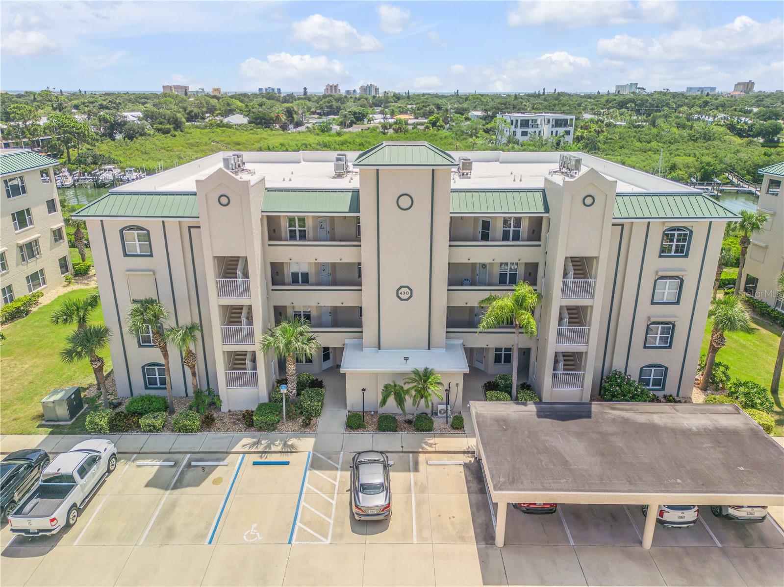 Coastal resort-style living, private boat access, and the security of your own deeded garage define this immaculate 3-bedroom, 3-bath corner unit on Bouchelle Island. Perfectly positioned along Callalisa Creek, this waterfront sanctuary includes a one-car garage (#8) for secure parking and storage, plus direct access to the Intracoastal with boat slips and storage for all your watercraft. Inside, a spacious foyer opens to a bright, open-concept layout filled with natural light from the corner location. The updated kitchen offers abundant cabinetry, a walk-in pantry, and generous counter space, flowing seamlessly into the living area with bar seating and out to a large screened porch—an ideal spot for alfresco dining, birdwatching, or enjoying views of passing boats and rocket launches. The Owner’s Suite provides private porch access and a spa-like bath with dual vanities, soaking tub, separate shower, and a large walk-in closet. Additional highlights include a convenient in-unit laundry room, solid concrete construction, and hurricane shutters for added peace of mind. Bouchelle Island amenities include two heated pools, an 18-hole pitch and putt golf course, tennis and pickleball courts, fitness center, clubhouse, walking trails, a boat ramp, and wet/dry slips. All just minutes from Flagler Avenue, Canal Street, and the beach—making this the epitome of New Smyrna Beach living.