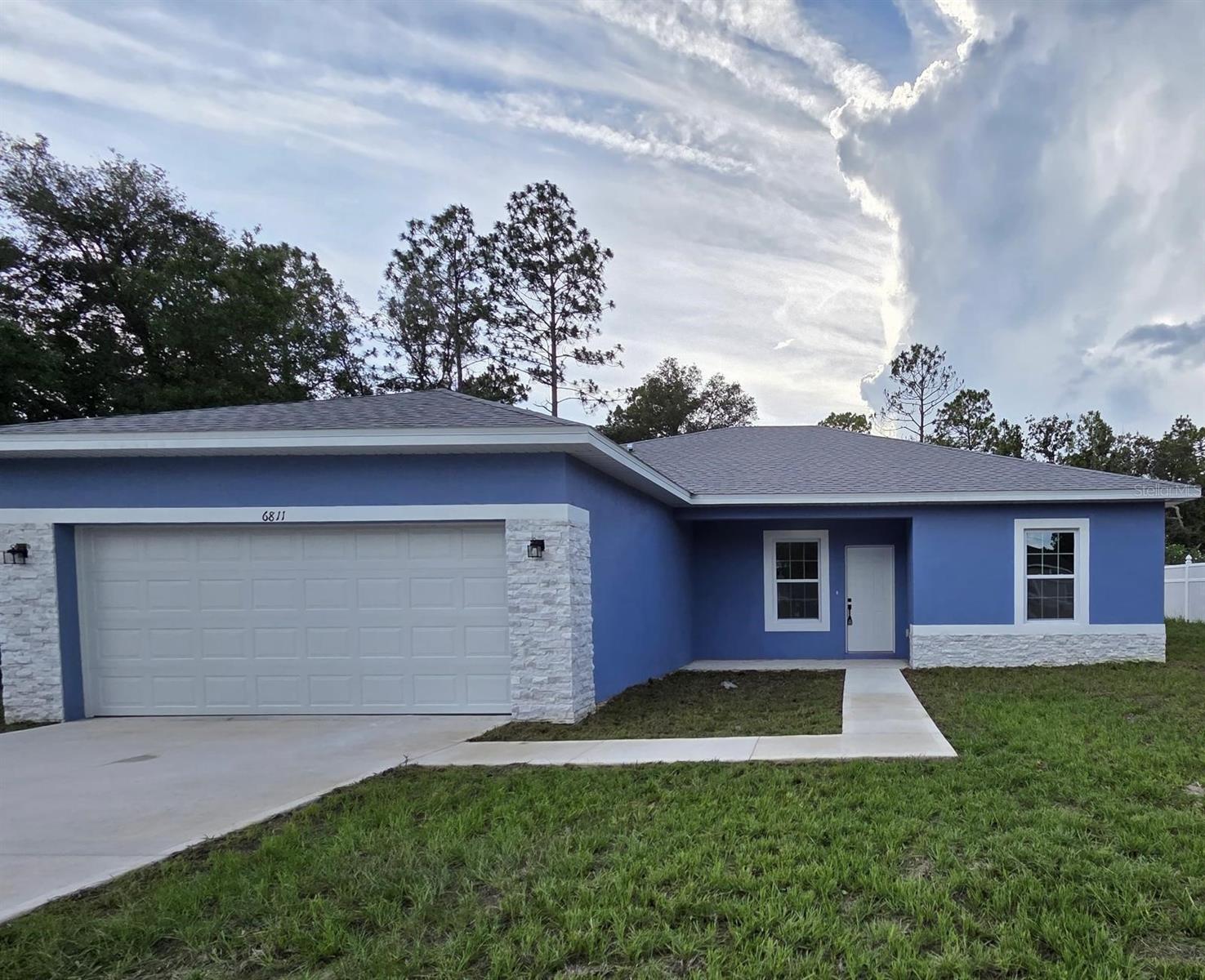 Welcome to this stunningly crafted home nestled in the sought-after Marion Oaks community of Ocala, Florida. Designed with a spacious open layout and a split-bedroom floor plan for enhanced privacy, this residence blends style, comfort, and functionality with ease.
Step inside to find luxury vinyl plank flooring throughout—both elegant and low-maintenance—offering a cohesive and durable foundation. The contemporary kitchen stands out with its crisp white shaker cabinets, port white quartz countertops, and bold matte black fixtures that create a striking visual contrast. Stainless steel appliances complete the space, making it ideal for daily living and effortless entertaining.
The primary suite is a true sanctuary, featuring a large walk-in closet and a spa-inspired en suite bathroom with a sleek soaking tub, separate walk-in shower, and private water closet. The additional bedrooms are spacious and versatile—perfect for guests, family, or a dedicated office.
Outside, the expansive backyard provides a perfect setting for entertaining, play, or simply soaking up the Florida sunshine in peace.
With its refined finishes and smart layout, this Marion Oaks beauty is sure to impress. Don’t miss your chance—schedule a private tour today and discover the perfect balance of modern design and timeless comfort!