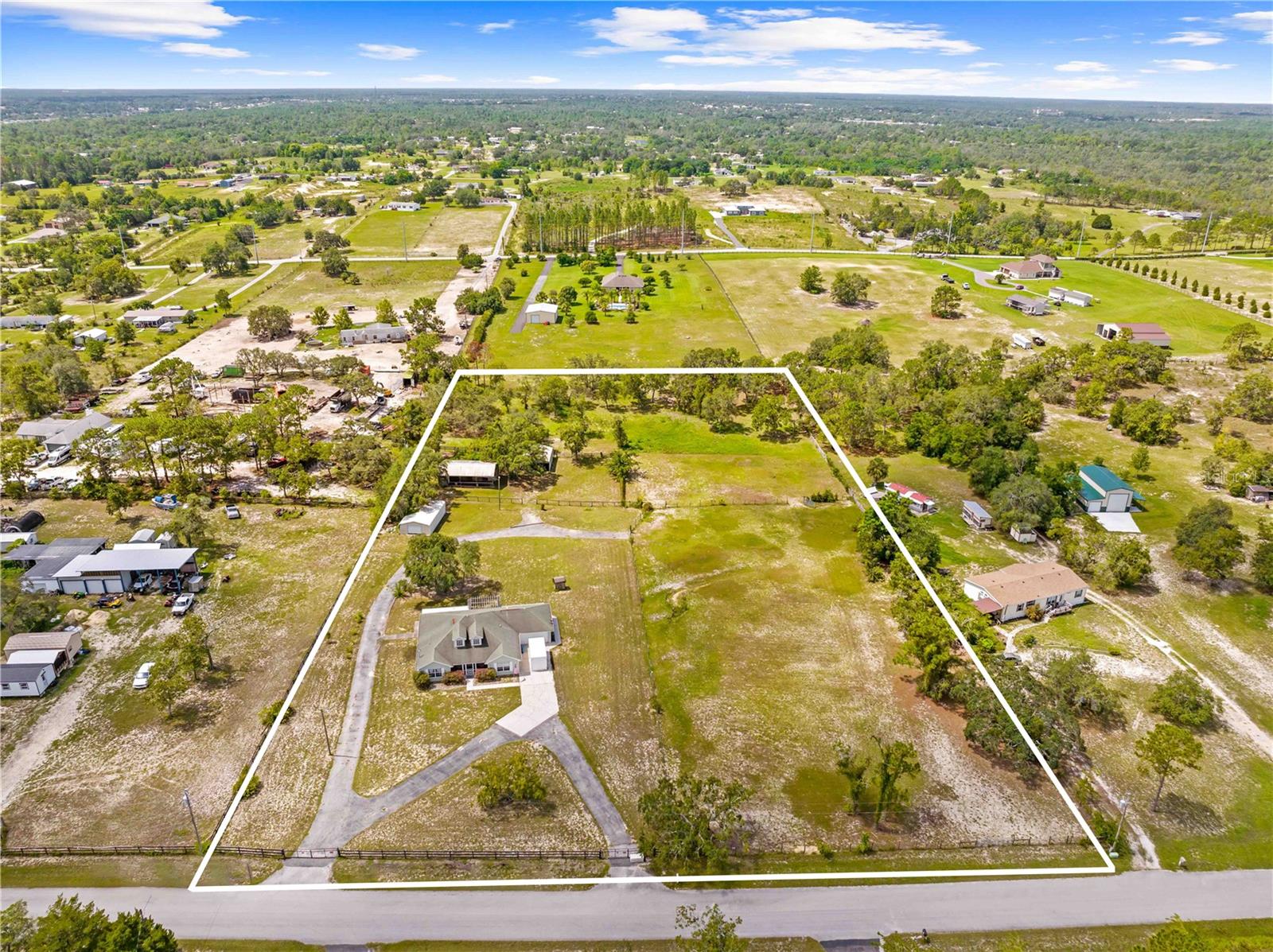 This beautiful 3-bedroom, 2-bathroom home sits on 5 acres in Brooksville and is perfect for horse lovers or anyone who wants space to enjoy the outdoors. The home features a split floor plan, with the main bedroom on one side and the other two bedrooms on the opposite side, giving everyone privacy. The kitchen is open to the living room, which has high cathedral ceilings and dormer windows that bring in lots of natural light.
You’ll love spending time on the screened front and back porches or relaxing under the pergola. The home also includes great safety features like lightning rods on both the house and the barn, an internal surge protector, and pre-wiring for a whole-home generator.
The land is fully fenced and cross-fenced, making it ideal for animals. There’s a 3-stall barn with a tack room, and each stall has its own paddock with fans, double Dutch doors, and back gates that open directly to the pasture. The barn has water and electric, plus a durable metal roof. You’ll also find a 25x31 hay barn, a 24x40 workshop, and plenty of parking for trucks, trailers, and guests.
The property is zoned Agricultural Residential and even allows for pigeon racing. If you’re looking for a peaceful place with room to enjoy your animals, hobbies, and nature—this is the one!