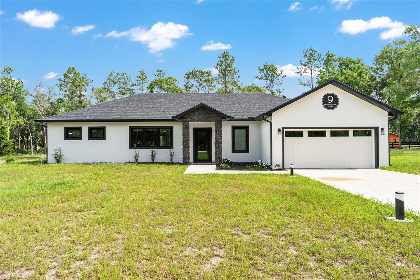 Better than new, this impeccably maintained 4-bedroom, 2-bath home sits on 4.3 partially cleared acres just 7 miles from the World Equestrian Center. Enjoy peace and privacy with perimeter 4 board/wire fencing, a new electronic gate, paved driveway and security system. The spacious interior features an open-concept living, dining, and kitchen area with French doors leading to a large screened patio—perfect for entertaining. The kitchen boasts quartz countertops, soft-close cabinetry, a wine cooler, and an upgraded hood vent. The primary suite includes dual walk-in closets with custom shelving and a luxurious zero-entry shower and double vanity. Guest rooms also offer custom closets, and the hall bath features LED lighting and a tiled shower. Additional upgrades include a high-efficiency Rheem heat pump water heater, spray foam attic insulation, upgraded windows with window treatments, and a whisper-quiet garage door opener with camera and remote access. This home blends modern comfort with country charm—ready for you, your horses and other furry friends.