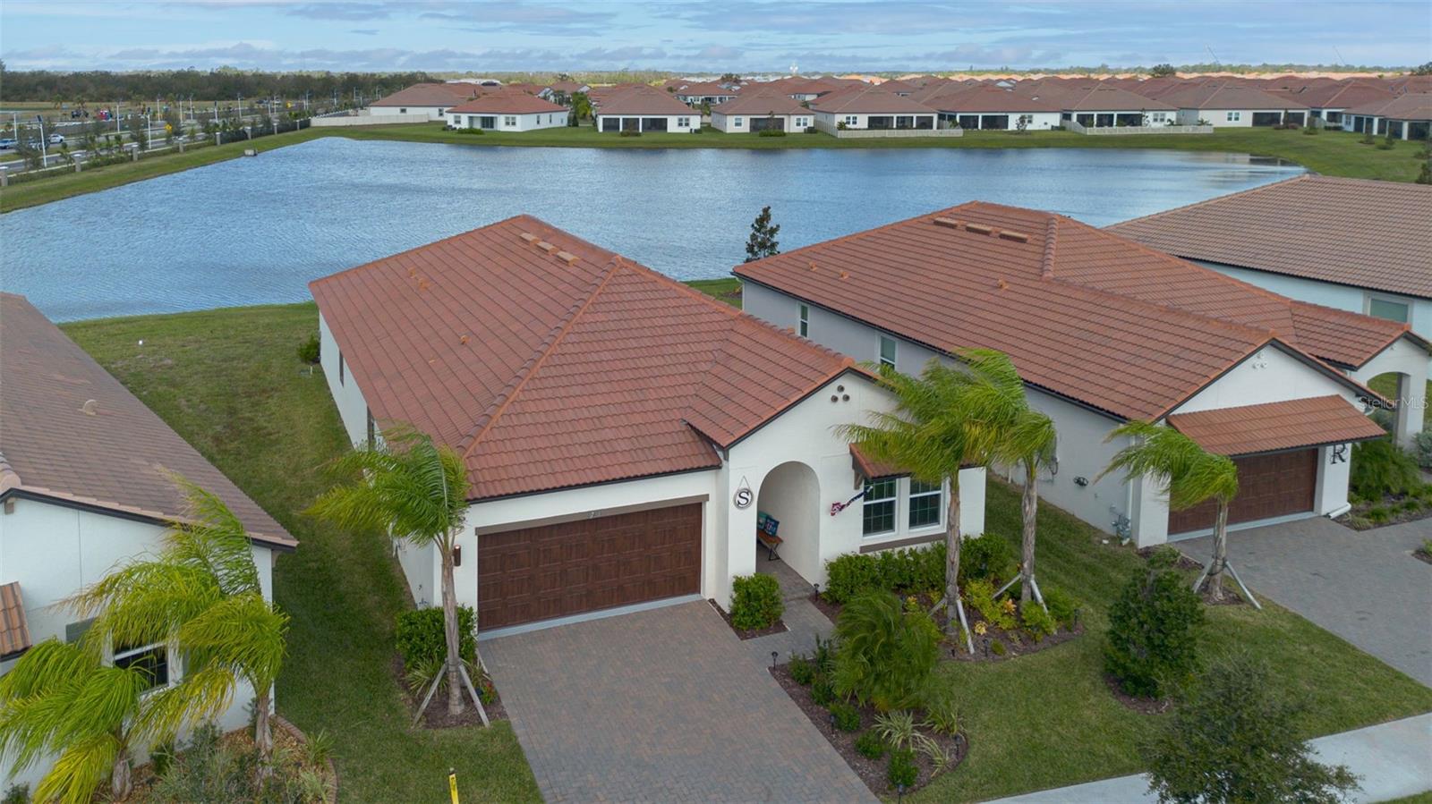 Beautiful 2BR & LG. FLEX ROOM home with POND frontage in Medley at Southshore Bay! This "premier" home w/ NO rear neighbors, offers you a splendid opportunity to enjoy an amazing home & lifestyle! This 55+ ACTIVE ADULT & gated community offers so very much! This 2BR, + LG. FLEX room, 2BA, & oversized 2 Car Garage home has an enormous, screened patio to watch the best of mother nature too! Relax within an open floorplan, quartz countertops, solid wood cabinets, upgraded lighting & fans, high ceilings, large center island, natural gas range, wi-fi refrigerator, & walk-in pantry w/in your kitchen area. Come see the crown molding, gorgeous porcelain tile throughout the main living area, motorized custom slider shades, & much more w/in the family room area - perfect for entertaining. This home offers a private layout, w/ split-plan design of your primary suite overlooking WATER VIEWS, a walk-in/walk-through closet, large bathroom (w/ custom bath door) and ample counter & vanity space! Enjoy your guest/2nd bedroom w/ an accommodating 2nd bathroom w/ a convenient layout. You'll also have many options w/ your VERSATILE FLEX ROOM/DEN/OFFICE. Your dedicated laundry room will impress, w/ its size & built-in cabinets! The oversized 2-car garage area has heavy duty storage racks (ceiling mount) for added space & your driveway/walk-up is elegantly paver designed! Your exterior also has full irrigation (front & back) & professional landscaping throughout! Lastly, the home has a natural gas on-demand tankless water heating system to enjoy! Your community has manned (main) & un-manned gated entrance/exit options for easy commuting to so many desirable areas. Medley at Southshore Bay offers an enormous array of recreational options, including pickleball, bocce courts, a dog park, trails & golf cart friendly paths. Your community clubhouse offers a cafe & bars, pool table, meeting/game room, formal Ballroom available for special events & a central mail kiosk. Residents can also enjoy the resort-style heated pool & walking trails - within reach of the amazing 5-acre crystal lagoon. HOA fees include internet & basic cable, exterior lawn maintenance, mulching, & trimming. Come see what amazing features this home & the SouthShore Bay community have in store for you! You will be glad you did!