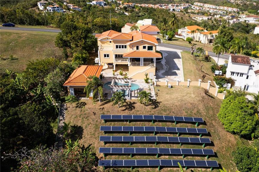 Gorgeous Estate located in the exclusive Beach Resort Community of Palmas del Mar on the east coast of the Caribbean paradise island of Puerto Rico. As you arrive through the convenient carport you'll enter through a light filled foyer and then onto an sitting area with class doors whith acess to the patio. Glance left, and youll find the dining area, living room and kitchen with a large island. The kitchen has been completely remodeled and decked with high end appliances and gas stove. Ideal for entertaining friends and family in a tropical ambiance while soaking in the views of the Caribbean Sea. 
The patio is one place you will throughly enjoy, the constant ocean breeze makes it a very comfortable and ideal place to lounge and read your favorite book while sipping a cup of warm Puertorrican coffee.  
On the same main level you will also find a bedroom, a shared full bathroom and an office.
On the second level you will find three more bedrooms, a library area, storage areas, terrace, laundry room, 2 bathrooms, and the expansive master bedroom with ensuite master bath and walk in closet. The master bath was beautifully remodeled featuring a self standing tub and shower which doubles as a steam room. Shower while soaking in the beautiful ocean views.
The lower level includes a three-car garage, storage areas, solar equipment room and an equipped theater. Exit through this level and you're in the pool area. The spacious pool area features a gazebo, with sound system, bbq, kitchen, a jacuzzi style hot tub, water features with beautiful lighting for those nights when you want to bring friends over and entertain. 

Fruit Trees:
The lot includes various kinds of fruit trees. You can enjoy an organic breakfast every single day!

Solar power:
This property is  powered by 14kw of solar panels, a total investment of more than 100,000.00. The current owner pays 0 in electricity bills. 

Power generator:
A 20K power generator is included as well for additional peace of mind. 
 
More about Palmas del Mar Resort:

Palmas Del Mar resort is a master planned, access controlled community, located in the east coast Puerto Rico. Palmas Del Mar is the most complete resort destination in the Caribbean boasting a range of world-class amenities that are just a golf-cart drive away, such as:

- A 60 acre tropical forest reserve
-  Grocery store, bank, retail stores, restaurants, professional services
- Two championship golf courses designed by Gary Player and Reese Jones
- World class marina and Yacht Club
- The largest Private Tennis Club in the Caribbean with all new pickleball courts.
- First-class Equestrian center with private stables and guided trail rides.
- 5 miles of coast of which 2 miles are beach.
- 8 miles of Golf cart paths
- Beach club with pools, waterslides, and hot tub

Families will have access to The Palmas Academy, one of the finest private schools on the island, which offers English language instruction from Pre-k to 12th grade.

Palmas Del Mar is a community like no other.

Proof of funds or bank pre-qualification required for showings.