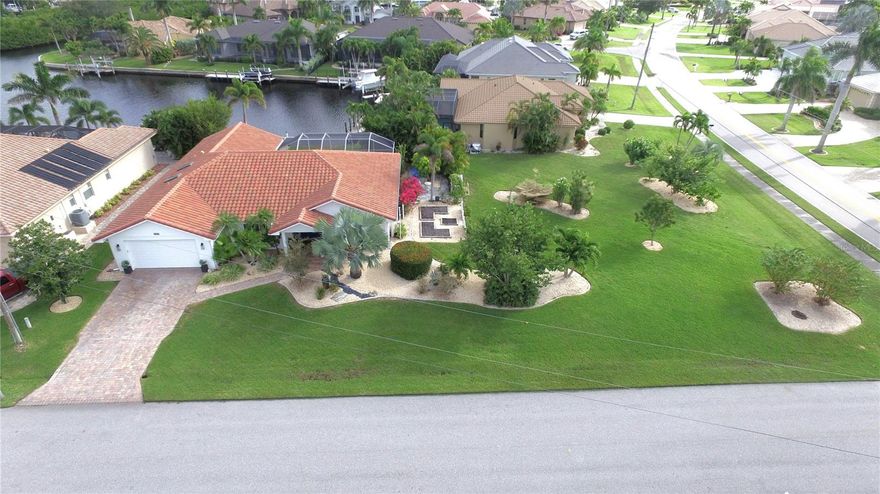 Welcome to Burnt Store Isles a boating and Golf and Country Club community where every home in this neighborhood is either on the water or on the golf course. A special place to live starts with a special home to live in and this home has it ready for you.  Measuring in at 2227 sq. ft. this home is a 3 bedroom and 2 bath home that has both a family room and living room along with a formal dining area and a kitchen dinette area.  The property sits on a oversized lot that is 14660 sq. ft. and has a very short boat ride to Alligator Creek which is the shortest path to the open water of the Charlotte Harbor and the Gulf of Mexico. The landscaping is next level as you can see in the pictures and it just makes you appreciate the pride of ownership as you pull into the driveway.  Once you enter the foyer, you will be amazed as this home has been remodeled throughout and the these pictures cannot do the home justice as it looks even better in person. You will immediately notice that it has new porcelain tile throughout that is installed in a herringbone pattern.  The bathrooms have new cabinets, walk in showers, bathing tub in the primary bathroom with his and her sinks that compliments the his and her walk in closets.  The kitchen is open to the family room and dinette, has beautiful cabinets and a quartz counter top that overlooks the pool area with a view to the canal water out back.  So many big ticket updates that I hope not to forget any.  A new roof in 2022, all new hurricane rated energy efficient vinyl slider windows in 2018. A electric roll down shutter for the front door in 2020. The pool was refinished in 2020.  A new air conditioner system in 2023. The garage floor was just redone with a commercial epoxy system in 2025. The water softner was installed in 2018.  A new water heater was installed in 2024. The layout of this home is absolutely perfect for entertaining for any get together or family holiday event.  The pool and lanai area are super private and you will find it difficult not to fall asleep out there with all the privacy. The covered area of the lanai is a 11 x 26 area that overlooks the refinished pool that is 13 x 26.  Then you will always enjoy the convenience because a Publix Shopping Center and a Home Depot is literally at one of the entrances into the neighborhood.  Downtown Punta Gorda and all it has to offer is just minutes away with all the fine dining restaurants along with your favorite sports bar or pub.  A miles long walking and biking path along the Charlotte Harbor is always a healthy treat as you pass so many historical and interesting parts of town including a drink at either Fisherman Village or the Titi Hut on the water.  A wonderful playground area at the park that overlooks the harbor.  Pickle ball courts all over town including the newer Pickleplex where weekly leagues and tournaments have turned into the new favorite sport for many of us locals.  Great events like the Christmas Tree lighting and Halloween downtown.  A favorite long time event is the Saturday Morning farmers market as well. For all you golfing enthusiast, there is 8 golf courses within a 20 minute drive as well. So call your realtor now to set up a private viewing of this amazing home that will be everything that were hoping.