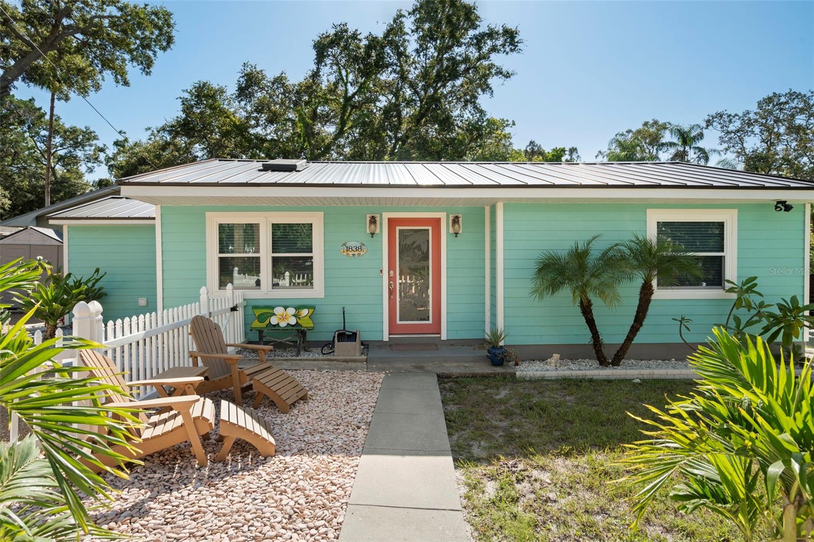 Looking for a white picket fence AND water access in an X500 flood zone? This charming bungalow in Clearwater is ready and waiting for you! Built in 1953, this home has been well maintained and recently upgraded with an aluminum roof (2024), hurricane rated windows and doors (2022), fiber-cement hardyboard siding (2022), new 200-amp electrical panel (2024), tankless water heater (2024), a whole house water softener with filtration system, and a new HVAC system! All the hard work has been done! Once through the front door, old Florida beauty shines through from the original blue tile bathroom to the galley kitchen. Boasting two generous bedrooms, the storage space in this home is impressive! Both bedrooms have ample closets, the primary being a large walk-in closet. But the closet is just one perk of the primary bedroom; tray ceiling lighting really sets off the whole space! Situated on a brackish canal, this property boasts outdoor living to the max! There are two designated entertainment spaces: the gorgeous 12-person, gas fed firepit, and the paved patio on the water. There is access to open water for a kayak, jet skis, or small boat. All furniture is negotiable. All red and brown Adirondack chairs convey with purchase. Call today for a private showing!