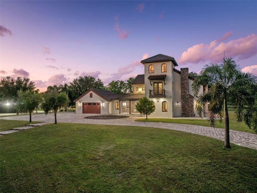 Welcome to 11205 Tindall Road – Experience the epitome of luxury living with this Lakefront Spanish Masterpiece by award-winning McNally Construction Group, perfectly set on a rare 10.42-acre gated estate in the heart of Lake Nona. Nestled along the serene southwest shore of Lake Hart, this one-of-a-kind property is among the largest remaining lakefront estates in the area—offering unmatched privacy, space, and security. A beautifully landscaped driveway leads to the home’s grand three-story façade, where panoramic lake views immediately capture your attention. Inside, the home exudes sophistication with a spacious living room, private office, and stunning glass-railed staircase. At the heart of the home, the chef’s kitchen, dining area, and great room impress with 20-foot vaulted ceilings, custom wood beams and tongue-and-groove detailing, and a breathtaking stone fireplace. A second-story glass balcony and floor-to-ceiling windows flood the space with natural light while framing endless lakefront vistas. The kitchen features custom cabinetry, dark granite countertops, and a large center island—perfect for entertaining. An elevator provides convenient access to the upper floors, where an expansive loft overlooks the great room. A spiral staircase leads to a third-floor bonus room/man cave with Dry Bar, offering the ideal space for relaxation or recreation. The residence features two luxurious master suites—one on each level—each with spa-inspired baths, walk-in closets, soaking tubs, and walk-in showers. Step outside to the screened lanai, complete with a summer kitchen and in-ground spa, creating the perfect setting for outdoor living. For water enthusiasts, the property includes a private dock with a boat lift, double jet ski lift, tile roof, and composite decking—ideal for days on the water. A 2,250 SF detached garage/workshop with bathrooms and dual 14’ roll-up doors offers ample storage for RVs, boats, and recreational vehicles. Other Notable Features- Fully Fenced, Fully Irrigated w/ (2) Wells, Entire Property covered by Closed Circuit Security System/Cameras, Multiple Gardens and more. This property is being Sold Fully Furnished with ALL Tractors, Boat and Equipment Included! Located just minutes from Medical City, Lake Nona Town Center, fine dining, shopping, and major highways, this estate offers the rare opportunity to enjoy secluded lakefront living without sacrificing convenience. Don’t miss this exceptional opportunity to own one of Lake Nona’s most extraordinary estates—schedule your private tour today.