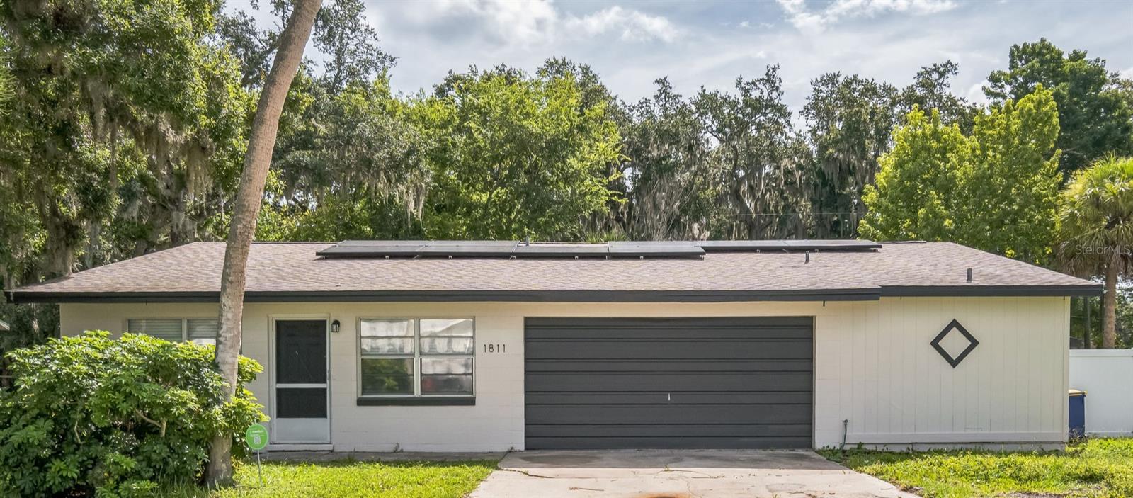 Welcome to 1811 Queen Palm Dr – a beautifully updated 3-bedroom, 2-bath home with 1,760 sq ft of living space, plus an incredible bonus in-law suite! This move-in-ready home is located in Edgewater with easy access to I-95 or US-1. Step inside to find a fresh coat of paint inside and out, brand new luxury vinyl plank flooring throughout, and upgraded baseboards for a modern, clean finish. The heart of the home features stunning new kitchen with shaker cabinets, sleek quartz countertops and stainless steel appliances. Home offers all-new fixtures and hardware. The open and functional layout offers comfortable living spaces, generous natural light, and plenty of room to entertain. The oversized 2-car garage provides ample room for storage or a workshop. Bonus: A fully attached studio in-law suite with private entrance, kitchenette, full bath, and its own fenced yard section – perfect for extended family, guests, or rental income potential (previously rented for over $1,000/month!). Additional features include solar panels to help drastically reduce monthly energy costs. Located in a quiet, established neighborhood in Edgewater, this home offers both modern upgrades and flexible living options. Come see this home today, you'll love what it has to offer!