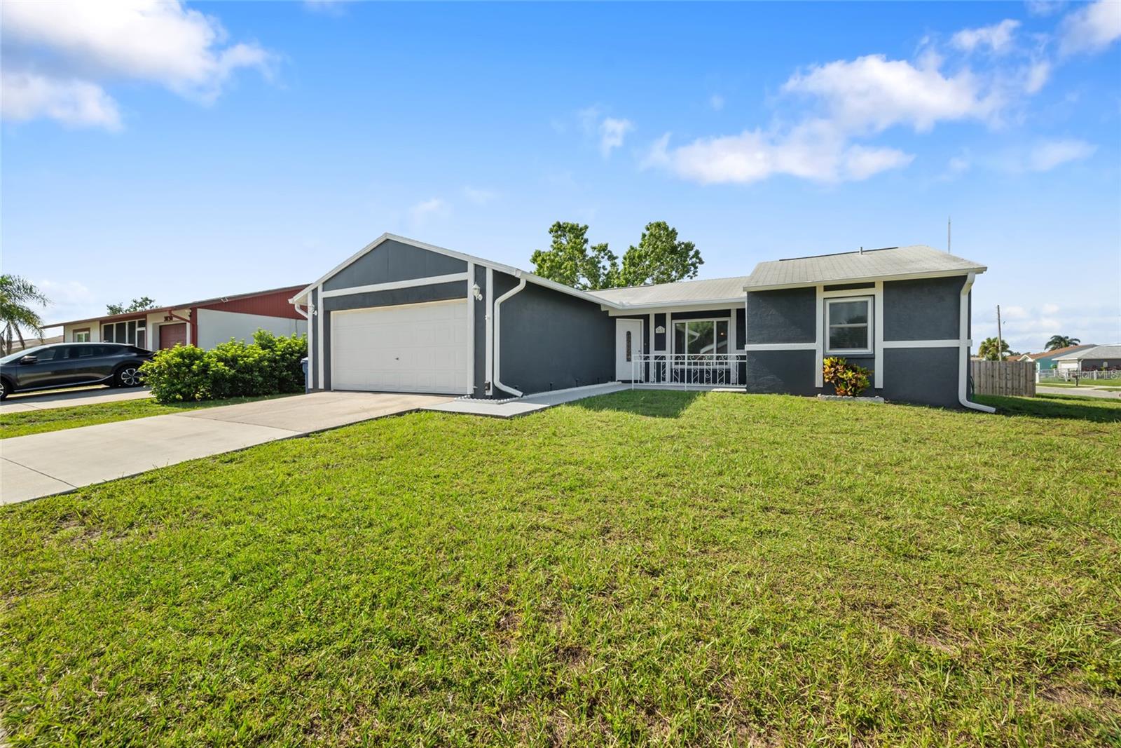 RARE FIND ~ Extra Large Corner Lot ~ Fully Renovated 4 bedroom, 2 bath, with bonus room & 2 car garage. Home is located within the highly desirable ALOHA GARDENS area of Holiday!! No flood or hurricane damage! No HOA! If you like to hear the word NEW, then this light & bright home is for you! This extra clean home shows true pride in homeownership and every detail has been thoughtfully updated to perfectly blend modern style with cozy comfort. The convenient split floor plan provides added privacy, with the primary suite separated from the other bedrooms. The additional bonus space is ideal for a home office, study area, nursery, or a kid’s playroom; perfect for today’s flexible living needs. Home has a new kitchen featuring pull out drawers, farmhouse sink, garbage disposal, ice maker and quartz countertops! Furthermore, the home features new bathrooms, new doors, new ceiling fans, new fixtures, new floors, newer storm windows, new duct work, newer AC (2020), new water heater (2024), new paint, new light fixtures inside and outside, newer fencing; all of which provides the feel of a brand-new home! Sitting on an oversized corner lot, the home has beautiful curb appeal, and as a bonus, offers a large front patio. New drainage system and new sidewalks were installed around the property in 2024. In addition, this gorgeous property has a large completely fenced in backyard, ideal for entertaining and summer BBQ’s, sitting by the fire or for your pets to run around. In terms of location, you could not ask for more. Great Schools and located right on the Pinellas County border, you'll enjoy convenient access to Tarpon Springs, the famous Sponge Docks, Howard Park, and Anclote Park. Whether you want to launch your boat or take a refreshing swim at the beach, the gulf is just a stone's throw away. Do not miss the opportunity to make this exceptional home yours. It has been meticulously maintained and is ready for you to simply move in and place your furniture. Embrace the luxurious lifestyle and make this house your forever home.