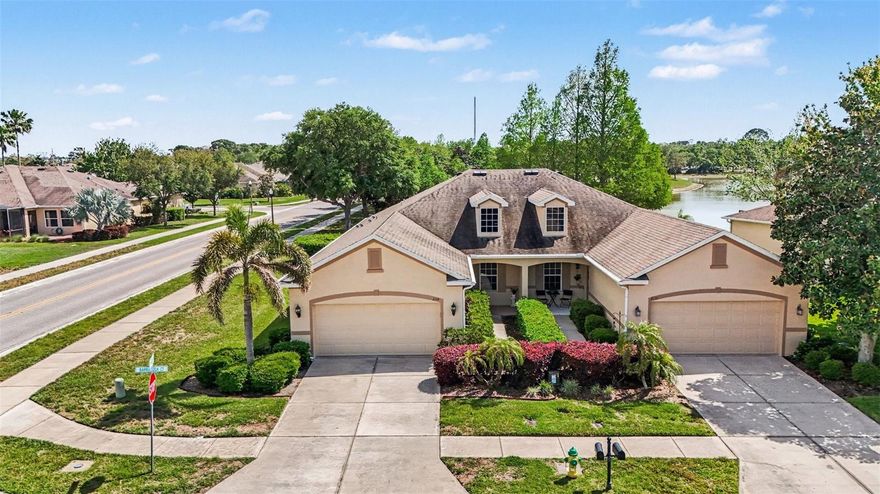 Do not hesitate on this meticulously maintained, one-owner villa in the Gulfwinds community. This exceptional corner-lot property is situated on a beautifully landscaped open space overlooking a pond, offering both privacy and scenic views. As one of the larger units available, the home features three bedrooms, two full bathrooms, and a dedicated den or office space complete with French doors and a decorative transom window. The interior is highlighted by high ceilings and porcelain plank tile flooring throughout. The kitchen is equipped with stainless steel appliances and quartz countertops, opening directly into a spacious great room. The split-bedroom layout ensures privacy for the owner’s suite, which includes dual vanities with updated granite tops, a garden tub, and a walk-in closet. Additional features of the home include a covered rear lanai, a brick paver patio, a separate laundry room with a washer and dryer, a generator, and a garage ceiling storage rack. The Gulfwinds community is an all-ages, pet-friendly neighborhood located in a no-flood zone. The monthly HOA provides significant value by covering lawn care, exterior maintenance (including the roof), internet, cable, and trash service. Residents also enjoy access to a resort-style pool and recreation area, as well as lighted sidewalks and a bike trail connected to the Pinellas Trail. The location is conveniently situated just ten minutes from the Sponge Docks, local marinas, parks, and top-rated schools. Whether you are looking for a primary residence, a seasonal retreat, or an investment opportunity, this villa offers an incredible combination of luxury and convenience.