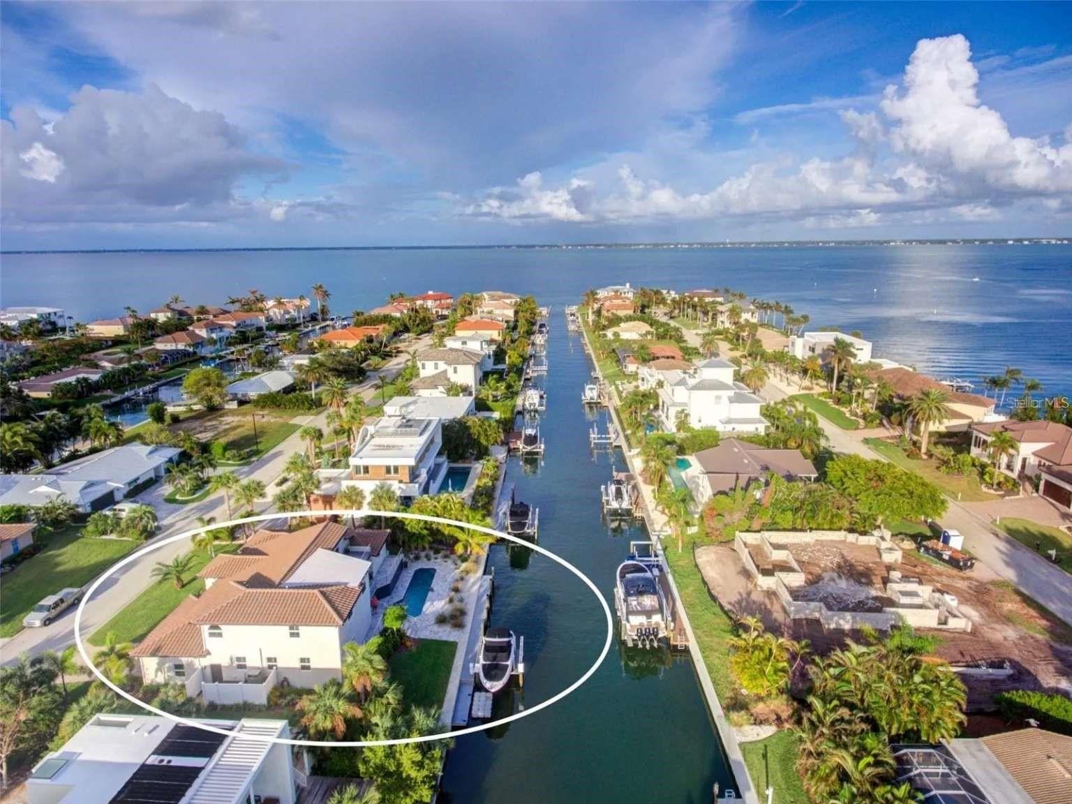 A rare opportunity to secure a single-family home with 100’ of canal frontage that has direct access to beautiful Sarasota Bay.— A RECENTLY RENOVATED home in beautiful Country Club Shores located on the more desirable southern end of Longboat Key. Home features 3,149 square feet of living space with 4-bedrooms and 3 full baths. Entering through an 8’ tall, arched iron front door you will discover a large great room with 16’ high ceilings and an open design concept . Completely replaced and renovated in 2018; tile roof, paver driveway, 2 Trane A/C units, tank-less water heater, sprinkler system, all railings, pool filter and pump. New stainless steel appliances, all interior doors and hardware, plantation shutters, LED lighting and porcelain tile floor throughout. The pool was refinished in deep blue Pebble Tec and is on the south (sunny) side of the property. The kitchen is spacious and open with solid wood, soft-close cabinets by Starmark and countertops in luxurious Cambria quartz. Boat lovers will appreciate the new seawall and the new 70’ private Trex dock with a 50 amp shore-power hookup and recently serviced 10,000 lb boat lift. — MOVE-IN READY with opportunity to personalize. The home offers an abundance of natural light and has a wide open floor plan with the current master bedroom on the upper level and three large bedrooms on the 1st level. The flexible layout offers the opportunity to create a 1st floor primary en-suite to suit your lifestyle. The existing large bedroom and bathroom with contemporary oversized his and hers sink vanity and large custom glass shower enclosure on the 1st floor can be customized to create a 1st floor master suite. — An exquisite solid oak, curved staircase leads to an upper-level deck with a water view. The owner’s suite features solid oak floors and his and hers walk-in closets. The master bath features handcrafted solid wood cabinets with quartz countertops, porcelain tile flooring, dual sinks, large enclosed shower and a whirlpool bath. —The first floor has three large guest bedrooms, one of which is set up as an office with custom built-ins. There are also two full baths which have similar features with the master bathroom; handcrafted solid wood cabinets with quartz countertops, porcelain tile flooring, and large enclosed showers. There is a large formal dining area adjacent to the curved oak staircase. — The covered lanai and outdoor living area has a spacious two-level travertine deck that is the perfect area for entertaining, sunbathing, and watching the dolphins that occasionally swim by. The FLEXIBLE living space makes this home perfect for extended family, visiting guests and working from home. You will enjoy an opulent waterfront lifestyle in this spacious home with direct canal access to Sarasota Bay. Enjoy the private deeded beach which has the most spectacular sugar-soft, white sand on the Gulf of Mexico. This property is close to everything. Longboat Key Club’s 27-holes of championship golf and shopping on St. Armands Circle. Sarasota, with it's rich cultural arts scene and many fine dining options are just a short drive away.