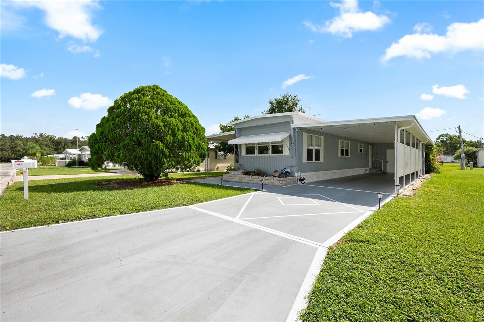 Pack your bags and get ready to enjoy Florida living at its best. This 2BR/1BA fully furnished, turnkey home with charming curb appeal is waiting for you in Betmar Acres, one of Zephyrhills’ most sought-after 55+ golf communities where you own your land and pay only a low $435 annual fee. Step inside to a beautifully updated and tastefully decorated home. Every detail, from the furniture and artwork to the décor and bedding, has been carefully coordinated to create a warm and inviting atmosphere. The open layout between the kitchen and living room makes entertaining family and friends effortless. The kitchen has been thoughtfully updated with newer appliances, cabinetry, backsplash, flooring, and lighting. The spacious owner’s suite easily accommodates a queen bed and full furniture set and features dual built-in closets, a ceiling fan, and a private bath with tiled step-in shower, granite vanity, tall toilet, and updated flooring. The second bedroom adds to the charm with its barn door, built-in closet, and updated flooring. One of the highlights of this home is the outdoor screen room off the side, complete with carpet flooring, updated lighting, window shades, and comfortable outdoor furniture—perfect for enjoying Florida’s weather year-round. An attached golf cart shed and carport provide added convenience. Living in Betmar Acres means access to an incredible lifestyle. Residents enjoy 27 holes of golf, two swimming pools, two hot tubs, three clubhouses, walking paths, game rooms with billiards and table tennis, miniature golf, shuffleboard courts, and much more. Call today to schedule your private tour and see firsthand all that this wonderful home and community have to present.