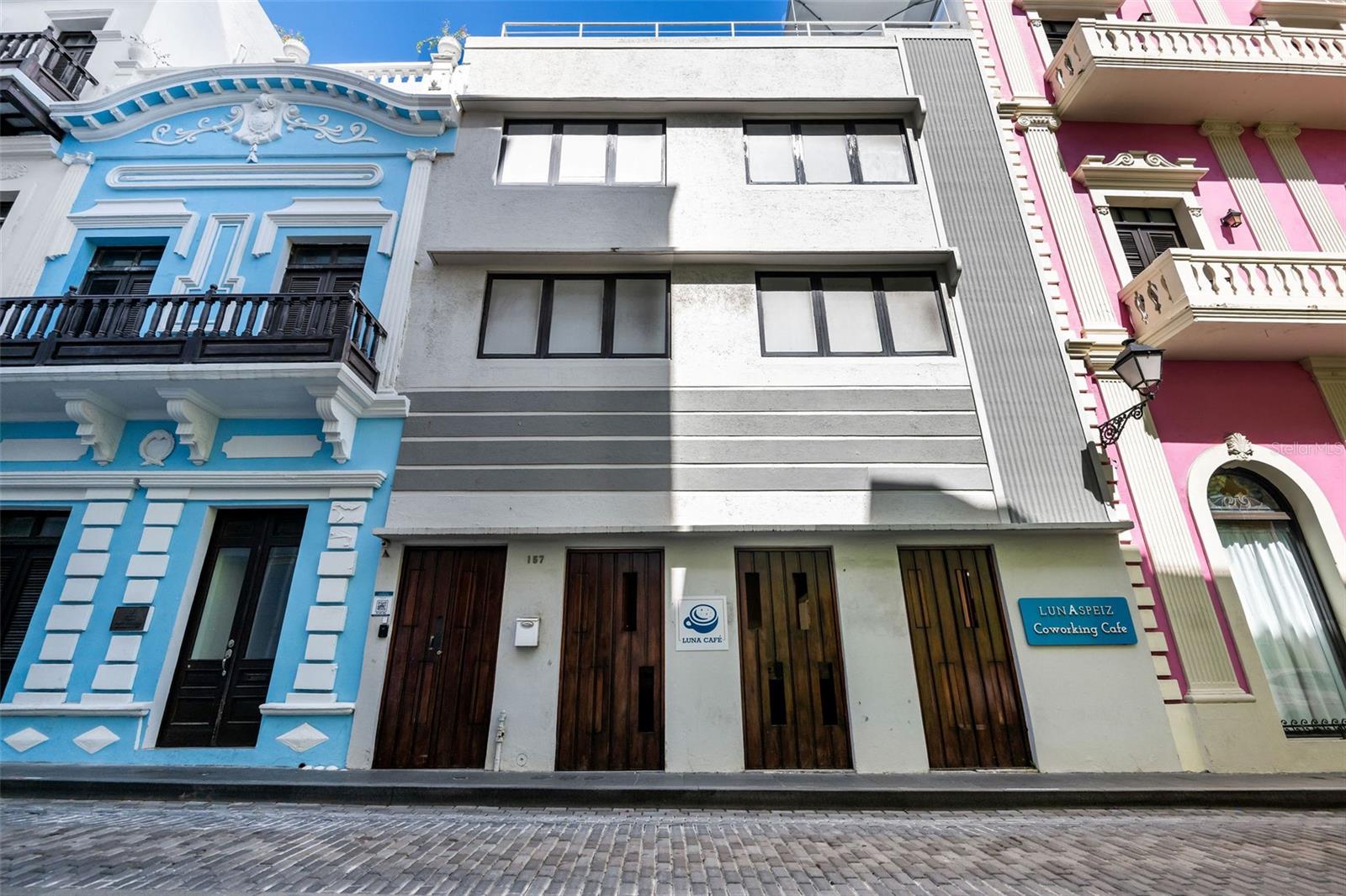 Nestled in the heart of historic Old San Juan, this exceptional three-story commercial property with a rooftop offers a unique blend of hospitality, coworking, and entertainment spaces. Originally built in the 1930s and thoughtfully remodeled in 2020-2021, it seamlessly blends historic charm with modern convenience. Just steps away from boutique shops, top-rated restaurants, and iconic landmarks like Castillo San Cristóbal and El Morro, this property enjoys high foot traffic and a prime location in Puerto Rico’s charming capital.
The ground floor features a welcoming restaurant and coffee shop at the front, perfect for capturing the daily buzz of the area, while the back houses a hidden speakeasy-style bar, offering an intimate nightlife experience. The second and third floors are dedicated to modern coworking and office spaces, designed for flexible rentals similar to Spece and Piloto, with private offices, meeting rooms, and shared workspaces catering to entrepreneurs and professionals.
Topping it all off, the rooftop boasts a stylish open-air bar with breathtaking views of Old San Juan, making it an ideal spot for social gatherings and private events. Whether as an investment or a business opportunity, this dynamic property seamlessly combines history, functionality, and income-generating potential in one of the most sought-after locations on the island.