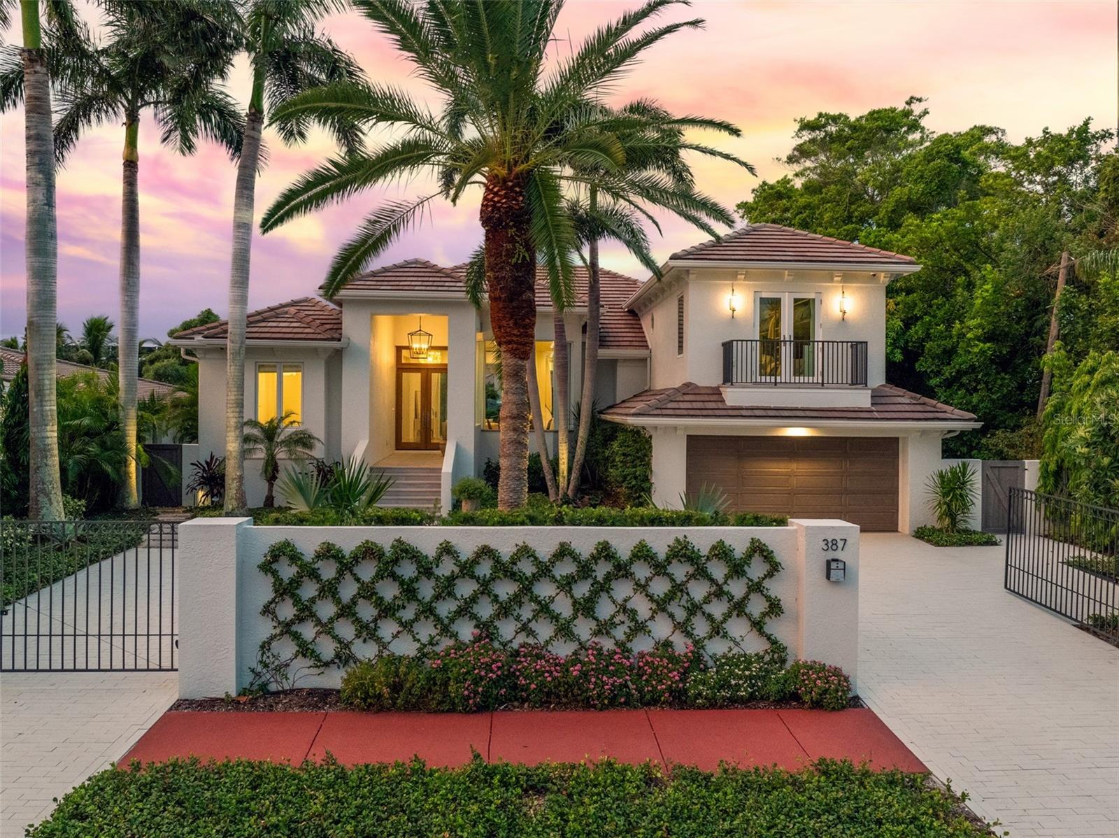 ST ARMANDS WATERFRONT RESIDENCE. This stunning canal-front home was distinctively reimagined and completely renovated in 2021 by Murray Homes with interior selections by Elizabeth Krueger Designs. A luxurious modern coastal retreat unlike any other with 3,268 sq ft of interior living space, this impressive open-concept design offers 4 bedrooms, and 5 full bathrooms. The unparalleled location boasts the best of Florida living with 82-feet of water frontage that includes a new seawall, dock and combination platform lift for Wave Runners /paddleboards. This private, gated residence is conveniently positioned just two blocks from St. Armands Circle, with its award-winning restaurants and shops, within walking distance of Lido Beach, and just a short drive from downtown Sarasota, or beachfront resorts and golf. Meticulous attention to detail is evident as soon as you approach the residence with architectural elements and designer finishes that showcase the unrivaled craftsmanship and exceptional design. Sophisticated accents throughout such as the custom entry doors, beautiful Aspen Spring Catalina Oak wood flooring, and voluminous ceilings with architectural accents in the dining room, family room, and primary suite, make this home the epitome of luxury and style. The gourmet kitchen is a showpiece at the heart of the open living space, with striking Calacatta Viola Monet marble countertops and backsplash, spacious island with seating, custom Windy Chien lighting installation, and maple cabinetry. The well planned space is fully equipped with top-of-the-line appliances including a 36” professional Wolf induction range, Thermador microwave and dishwasher, and Sub-Zero refrigerator. A custom open walk-in pantry with floating shelves and maple cabinetry in a coastal finish, adds both convenience and style. The private primary suite is a true luxury retreat, beautifully appointed with designer finishes such as a vaulted tongue-and-groove wood ceiling, sliders that open wide to the terrace, a generous custom walk-in closet, and an exquisite en suite bathroom. A second spacious suite rivals the primary bedroom to delight your guests with sliders that open to the water, a custom walk-in closet, and a fabulous en suite bathroom with dual vanities, and seamless glass walk-in shower. The 3rd bedroom is adjacent to the main bathroom, and off the kitchen is the stylish laundry room with quartz counters, an apron sink, and built-in cabinetry. The upstairs brings you to the lofty bunkroom, the 4th bedroom, with French doors to the private balcony, and en suite bathroom. The zoned A/C systems are an added convenience, including a mini-split system in the oversized 2-car garage that greets you in comfort as soon as you pull in from the private and gated paver driveway. Magnificently spacious and open, the home’s interior design seamlessly extends outdoors to the waterfront through generous windows and expansive sliding doors that open from the living areas to covered terraces, manicured hardscapes, and the relaxing canal-front pool, spa, and dock. The Southwestern rear exposure and tropical landscape make an ideal backdrop for picturesque sunsets over the intracoastal waterway, and the versatile indoor/outdoor living space is ideal for memorable gatherings. Live the island dream from sought-after St Armands Key, in this luxuriously renovated waterfront coastal sanctuary.