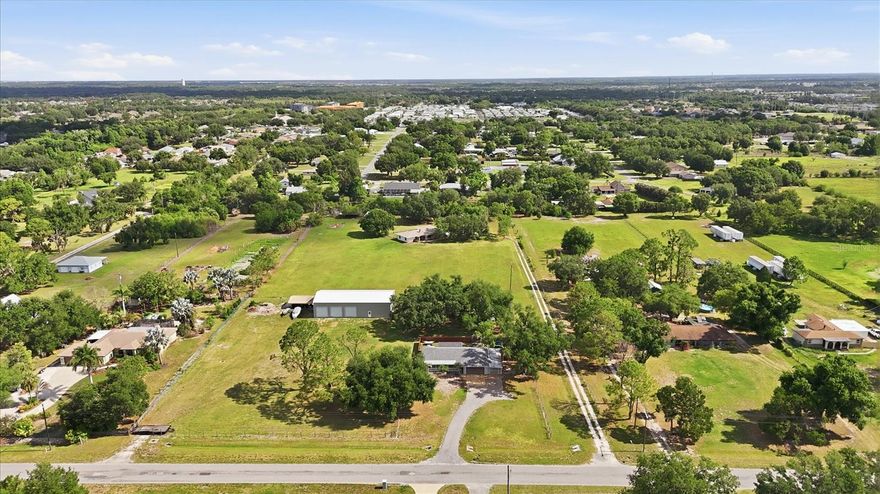 Sprawling 3.7-acre agricultural property in a great location with endless potential and NO HOA, NO CDD fees, and NO deed restrictions! Properties like this are rarely available, especially with this combination of usable acreage, flexible zoning, and massive workshop space. If you’ve been searching for room to run your business, store equipment, park work vehicles, or simply enjoy space and freedom, this property delivers.

The 1,925 sq. ft. concrete block home offers solid construction and a stunning oversized red brick fireplace that serves as the centerpiece of the living area. While the home is dated and ready for your personal updates, the possibilities here are tremendous.

Outside is where this property truly shines. In addition to the oversized 24x24 garage, you’ll find an impressive 30x60 detached concrete block shop — ideal for contractors, mechanics, landscapers, car enthusiasts, agricultural use, or business owners needing serious workspace and storage. Plenty of room for trailers, heavy equipment, fleet vehicles, boats, RVs, or future expansion.

Major updates already completed with new roofs installed in 2022 on both the home and detached shop. Rare opportunity to own usable acreage with flexible agricultural zoning and space to live, work, and grow — all in a convenient location close to shopping, dining, and major commuting routes, without restrictive community rules.