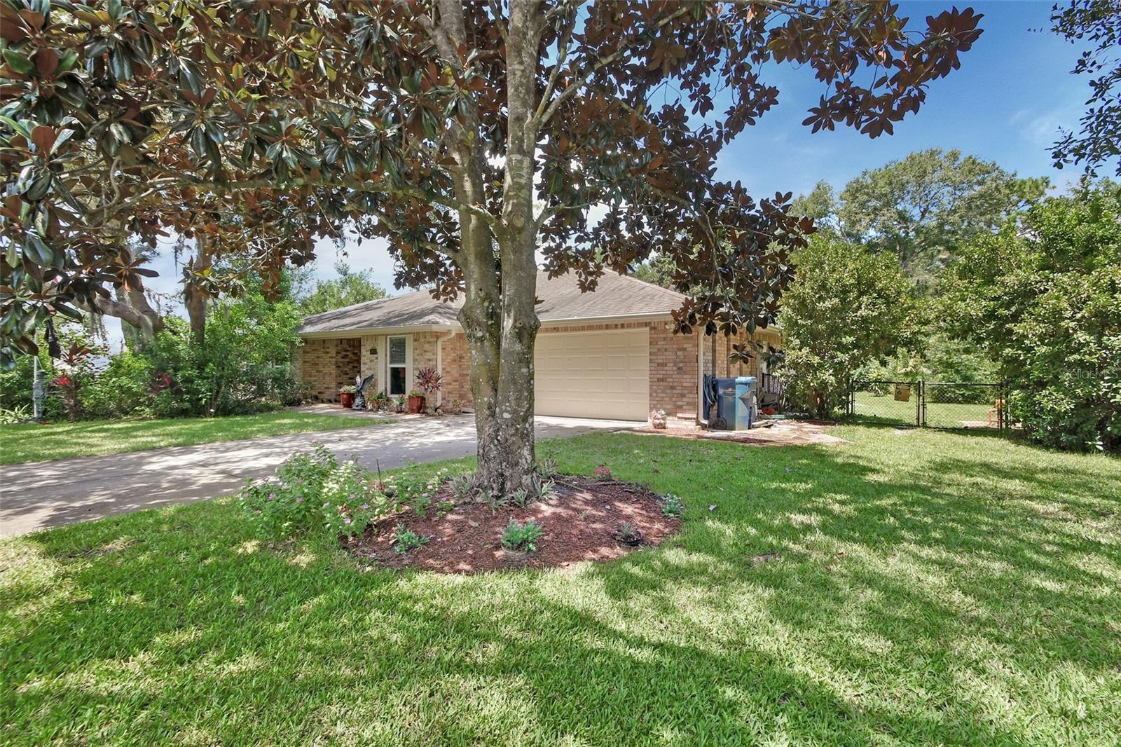 Charming, Well-Maintained Custom Brick Ranch in Gated DeLand Community!
Welcome to this beautifully crafted and very well-maintained custom brick ranch home, ideally located in the peaceful, gated community of Lakeshore Trail. This thoughtfully designed residence features 3 spacious bedrooms, 2.5 baths, and a 2-car garage, offering timeless charm, comfort, and functionality.
From the moment you arrive, you’ll be greeted by majestic, stately magnolia trees in both the front and backyard — adding classic Southern elegance, natural shade, and year-round beauty to the landscape.
Inside, the home boasts a gorgeous, gourmet kitchen featuring a large center island, granite countertops, and upgraded wood cabinetry — perfect for cooking, entertaining, and everyday living.
The oversized indoor laundry room, conveniently located off the kitchen, provides ample storage and a practical workspace to make daily tasks easier.
Enjoy the outdoors on the expansive covered porch, ideal for al fresco dining or quiet mornings. The lushly landscaped, fully fenced backyard offers a peaceful retreat, highlighted by a picturesque fountain and the continued beauty of mature magnolia trees.
A dedicated well for irrigation helps keep the lawn and garden vibrant year-round — an added bonus for efficiency and cost savings.
Blending classic architecture with tasteful upgrades, this elegant home offers exceptional living in a quiet, friendly neighborhood — just minutes from DeLand’s charming downtown, shopping, and recreation.