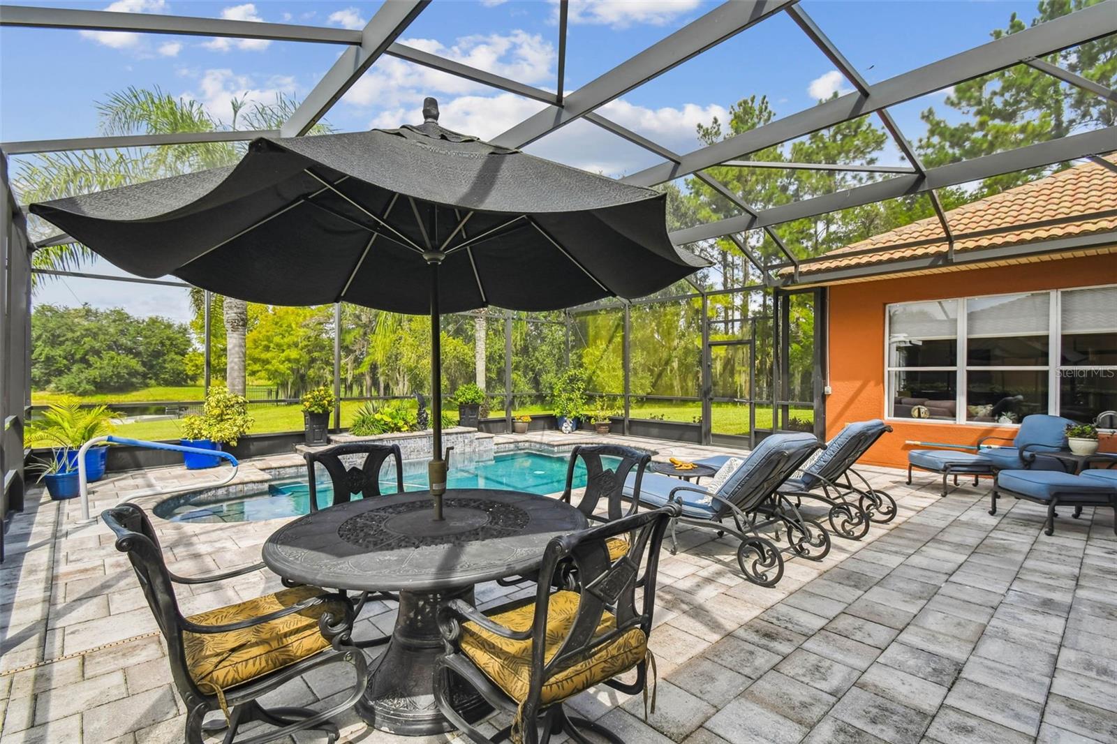 Stunning Custom-Built 3 Bedroom, 2 Bath Operetta Model Home perfectly situated on a quiet cul-de-sac with serene water views, a heated saltwater pool, and a spacious 2-car plus golf cart garage. Every detail of this property has been thoughtfully designed, blending luxury, comfort, and functionality. Set on an oversized premium lot, this 2,450 sq. ft. residence offers expansive living space with breathtaking water views that can be enjoyed from multiple vantage points. The outdoor living area is truly exceptional, featuring an expanded, screened, and covered lanai with a sparkling saltwater pool installed in 2021, complete with a heating system for year-round enjoyment. The outdoor kitchen creates the perfect setting for entertaining, with plenty of space for relaxing, dining, and soaking in the views of the tranquil water beyond. Step inside through the screened front porch and custom-designed entry door into the inviting great room, where natural light pours in and panoramic views of the pool and water become the home’s focal point. Adjacent to the great room is the Florida room, offering a cozy retreat with a view, while the breakfast nook provides a charming space to enjoy morning coffee as you watch the sunrise. The chef’s kitchen is a true highlight, featuring upgraded cabinetry, elegant countertops, a convenient eat-at bar, tile backsplash, and pull-out drawers for easy storage. Its thoughtful layout ensures both practicality and style, making it a central gathering place for family and friends. The spacious primary suite boasts a tray ceiling and an en-suite bathroom designed for comfort and relaxation. Enjoy the garden tub, walk-in shower, and dual vanities with double sinks, all complemented by two oversized walk-in closets offering ample storage space. Guest bedrooms 2 and 3 are located on the opposite side of the home for added privacy, making this a perfect layout for hosting family and visitors. Additional features include a large 2-car garage with a separate golf cart garage, providing abundant storage and convenience. This home is enhanced by a number of upgrades, including a whole-house water softener, an energy-efficient radiant barrier with core fill for green efficiency, crown molding throughout, trey ceilings, and upgraded tile flooring laid on the diagonal for a refined finish. The HVAC system was replaced in 2017 for peace of mind, and the durable Tuscan-style tile roof adds timeless beauty and curb appeal. Combining elegance with modern functionality, this home’s open and welcoming floor plan provides the perfect blend of indoor and outdoor living. From its premium cul-de-sac location and serene water views to its extensive list of upgrades, this residence is a true gem designed for both everyday comfort and unforgettable entertaining.