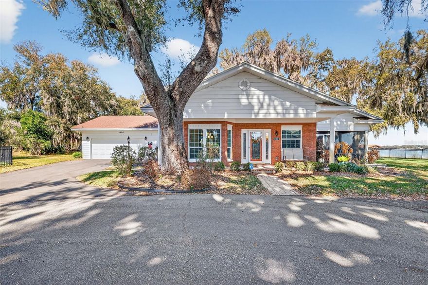 Welcome home to this stunning three-bedroom, two-bath retreat on the shores of Lake Griffin, part of the coveted Chain of Lakes.  From the moment you arrive, the charming brick front and curb appeal set the tone for what's inside.  Step into an open, light-filled living space featuring rich engineered hardwood floors and breathtaking lake views that instantly steal the showl  The heart of the home is the gourmet kitchen, anchored by an impressive 14-foot granite countertop-perfect for entertaining, casual meals, or gathering with friends and family.  Premium black stainless steel appliances, including  Sub-Zero refrigerator, elevate both style and performance.  The indoor laundry room and oversized garage add everyday convenience, while the tankless hot water heater ensures endless comfort.  Unwind on the screened-in lanai as you take in serene water views and unforgettable sunsets. NEW tankless hot water tank & New A/C unit. The property also includes a deeded dock, offering direct access to boating, fishing, and lake life right from your backyard.  This is more than a home-it's a lifestyle!  If you've been dreaming of waterfront living with high-end finishes and effortless Florida Charm, you just found it!