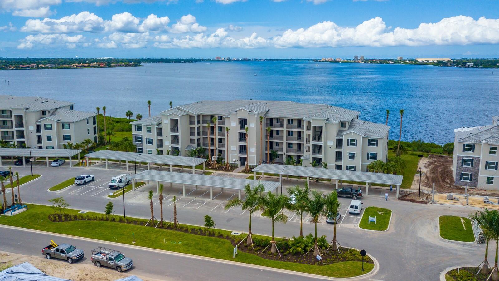 Luxury Riverfront Condo in Tidewater Preserve. Enjoy breathtaking nightly sunsets and watch boats glide by from your beautifully upgraded first-floor condo in Bradenton’s premier riverfront boating community, Tidewater Preserve. This coastal-inspired 2-bedroom, 2-bath Birkdale model is packed with premium upgrades and offered turnkey and fully furnished, including a Natuzzi leather sofa with three built-in recliners and an adjustable king bed in the primary suite. Designed for both comfort and style, this Alexa-enabled smart home features hurricane-impact windows, crown molding throughout, and tile flooring in the main living areas, with engineered hardwood in the bedrooms. The kitchen is a true showpiece, showcasing shaker-style cabinetry, a striking tile backsplash, stainless steel appliances, pendant lighting, and a spacious one-level quartz island. Grasscloth wallpaper adds a warm, textural accent to the adjoining dining area, which comfortably fits a table for four or a cozy bistro set. Smart-home upgrades include a Ring doorbell system, coded keyless entry, a Honeywell smart thermostat, and a reverse osmosis water filtration system. Additional custom features include remote-controlled blinds in the living room and a fully built-out California Closet system in the primary bedroom. The luxurious en-suite bath offers quartz countertops, shaker cabinetry, and a sleek walk-in shower. The guest bedroom doubles as a stylish custom home office, complete with an integrated Murphy bed—perfect for guests or remote work. Start your day with coffee on the private screened lanai while enjoying peaceful, unobstructed views of the Manatee River. This home also includes an assigned covered parking space and a private storage unit for added convenience. Tidewater Preserve offers more than a home—it’s a lifestyle. Residents enjoy world-class amenities including a private marina, three resort-style pools, two fitness centers, tennis courts, a dog park, playground, kayak launch, and scenic walking trails along the riverfront.