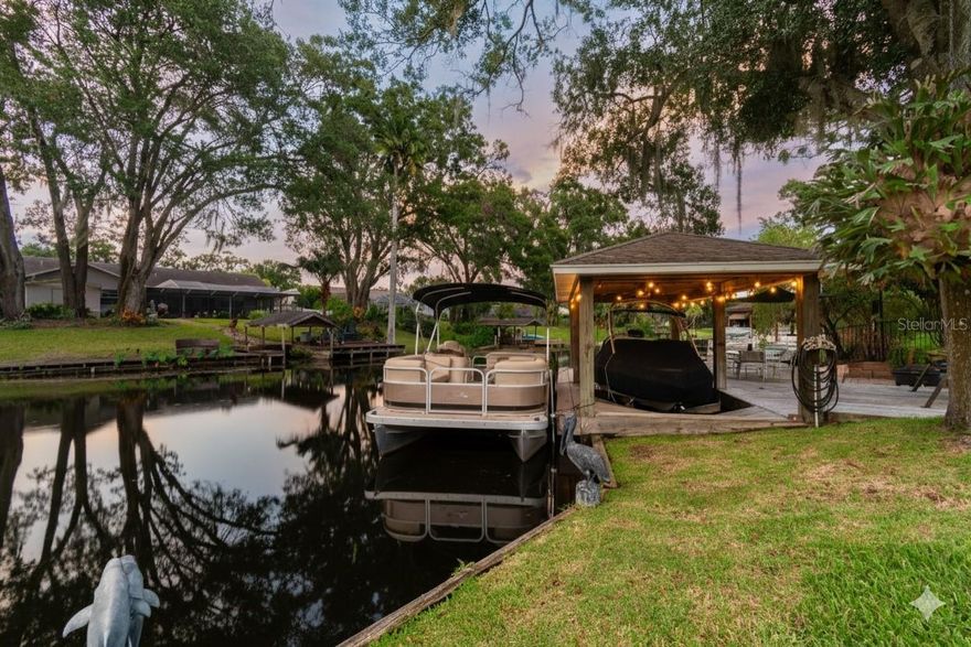 YOUR PRIVATE WATERFRONT OASIS AWAITS!
They say a photo never does a sunset justice, and we challenge you to come see for yourself why this lakefront home is the perfect place to witness a different one every evening. Imagine entertaining alfresco-style as the sky puts on its nightly show over East Lake—a 95-acre freshwater paradise, perfect for bass fishing and weekend water skiing. This home has been so meticulously maintained that it is completely turnkey; no waiting on paint bids or flooring samples. Your new home is ready when you are.

This is true lake life, where mornings are spent on the water and evenings are for quiet cruises. Your private waterfront setup is second to none, featuring an expansive boardwalk and deck that lead to a covered boathouse with an electric boat lift. The entire setup is supported by a seawall that was newly repaired in 2023, ensuring your personal dock is ready for years of enjoyment.

An impressive, oversized driveway, extended in 2023 to provide ample space for a boat or RV, and immaculate landscaping with elegant outdoor lighting create an unforgettable first impression. The welcoming foyer opens into a thoughtful and versatile layout, featuring an elegant formal dining room ready for holiday feasts and a spacious home office with a large storage closet—perfect for remote work or use as a fourth bedroom.

The expansive kitchen acts as the central hub of the home, connecting the multiple living spaces. It flows into a casual dining area and the main living room, where a beautiful fireplace with a prominent hearth creates a warm and inviting atmosphere. This home offers incredible flexibility, including a massive game room (approx. 15' x 24') that provides the ultimate space for recreation.

The highly desirable split-bedroom layout ensures privacy for everyone. A secluded primary suite serves as a true retreat with its large en-suite bathroom. On the opposite side of the home, a guest wing features two additional bedrooms and a full bathroom conveniently located for quick access from the pool.

The home’s interior flows seamlessly to a spectacular backyard oasis designed for ultimate relaxation. A stunning, lagoon-style pool serves as the centerpiece, featuring a custom-built privacy wall with soothing water features. Host unforgettable gatherings at the covered outdoor kitchen and bar area, enjoy quiet dinners under the charming pergola, or find your personal retreat in the versatile, finished 'she-shed.'

Move in with confidence knowing this home has been thoughtfully upgraded. A brand new septic system and a new pool pump motor were both installed in 2025. The outdoor living spaces have been enhanced with new step-down decking to the boat dock (2022). Major systems are also updated, including a full roof replacement in 2015 and a newer water heater from 2019.

Enjoy all of this with the freedom of NO mandatory HOA or CDD fees. The property is located in Flood Zone X and is zoned for A-rated schools like Charles S. Rushe Middle and Sunlake High. Lake Padgett neighborhood has private waterfront parks with boat ramps, picnic pavilions, restrooms, playgrounds, grills, fishing docks and lakes, pickleball & tennis courts, & is located right near the 79 acre Land O Lakes Recreation Center, where they have a skate park, gymnasium, tennis/pickleball courts, baseball/softball fields, dog park, picnic area, shelters, basketball courts, football/soccer fields, volleyball, & swimming pool.
