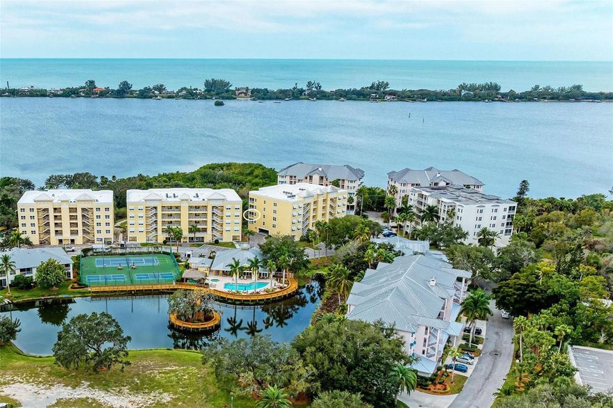 Enjoy sweeping water views and stunning sunsets over Little Sarasota Bay from this spacious third-floor corner residence in the gated waterfront community of Edgewater at Hidden Bay. Built in 2018, this three-bedroom plus den, 2.5-bath condominium offers nearly 2,200 square feet of living space with easy elevator access and one assigned parking space in the building. The attractive open floor plan features soaring ceilings, impact-rated windows and sliding doors, easy maintenance tile plank flooring and abundant natural light throughout. The kitchen includes granite countertops, solid wood cabinetry, stainless steel appliances and custom storage with pullout drawers. The living area offers a built-in dry bar with wine refrigerator and opens to a large, screened-in terrace with privacy-screens and expansive bay views. The primary suite includes dual walk-in closets and a luxurious bath with dual quartz vanities, decorative tile flooring, makeup vanity and walk-in shower. Additional features include a private den/office, in-unit laundry room, two full baths and a powder room. Edgewater at Hidden Bay is a gated, resort-style community set on 14 acres along Little Sarasota Bay and the Intracoastal Waterway, directly across from Casey Key. Community amenities include a waterfront clubhouse with kitchen and quartz bar, heated pool and spa, fitness center, library, tiki hut with grilling stations, pickleball and tennis courts, kayak launch, fishing pier, dog play area, and an elevated boardwalk through mangroves and palm-lined grounds. Hidden Bay is conveniently in Osprey just south of Sarasota, near area beaches, shopping and dining, and only minutes from Venice.